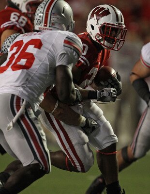 MADISON, WI - OCTOBER 16: James White #20 of the Wisconsin Badgers runs as Brian Rolle #36 of the Ohio State Buckeyes closes in at Camp Randall Stadium on October 16, 2010 in Madison, Wisconsin. Wisconsin defeated Ohio State 31-18. (Photo by Jonathan Dani
