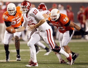 STILLWATER, OK - NOVEMBER 27:  Quarterback Landry Jones #12 of the Oklahoma Sooners hands the ball off against the Oklahoma State Cowboys at Boone Pickens Stadium on November 27, 2010 in Stillwater, Oklahoma.  (Photo by Tom Pennington/Getty Images)