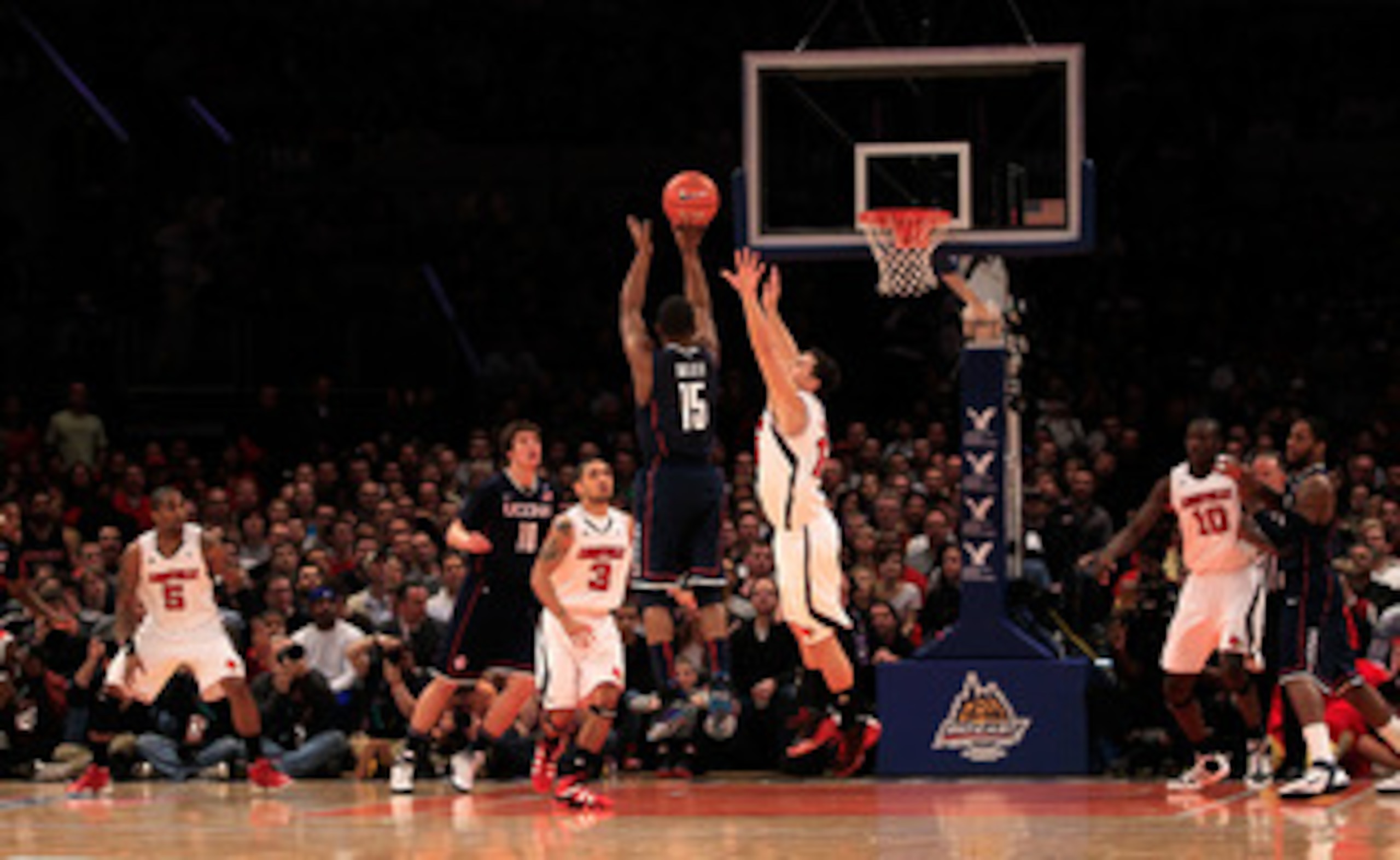 NEW YORK, NY - MARCH 12: Kemba Walker #15 of the Connecticut Huskies shoots over Kyle Kuric #14 of the Louisville Cardinals during the championship of the 2011 Big East Men's Basketball Tournament presented by American Eagle Outfitters at Madison Square G