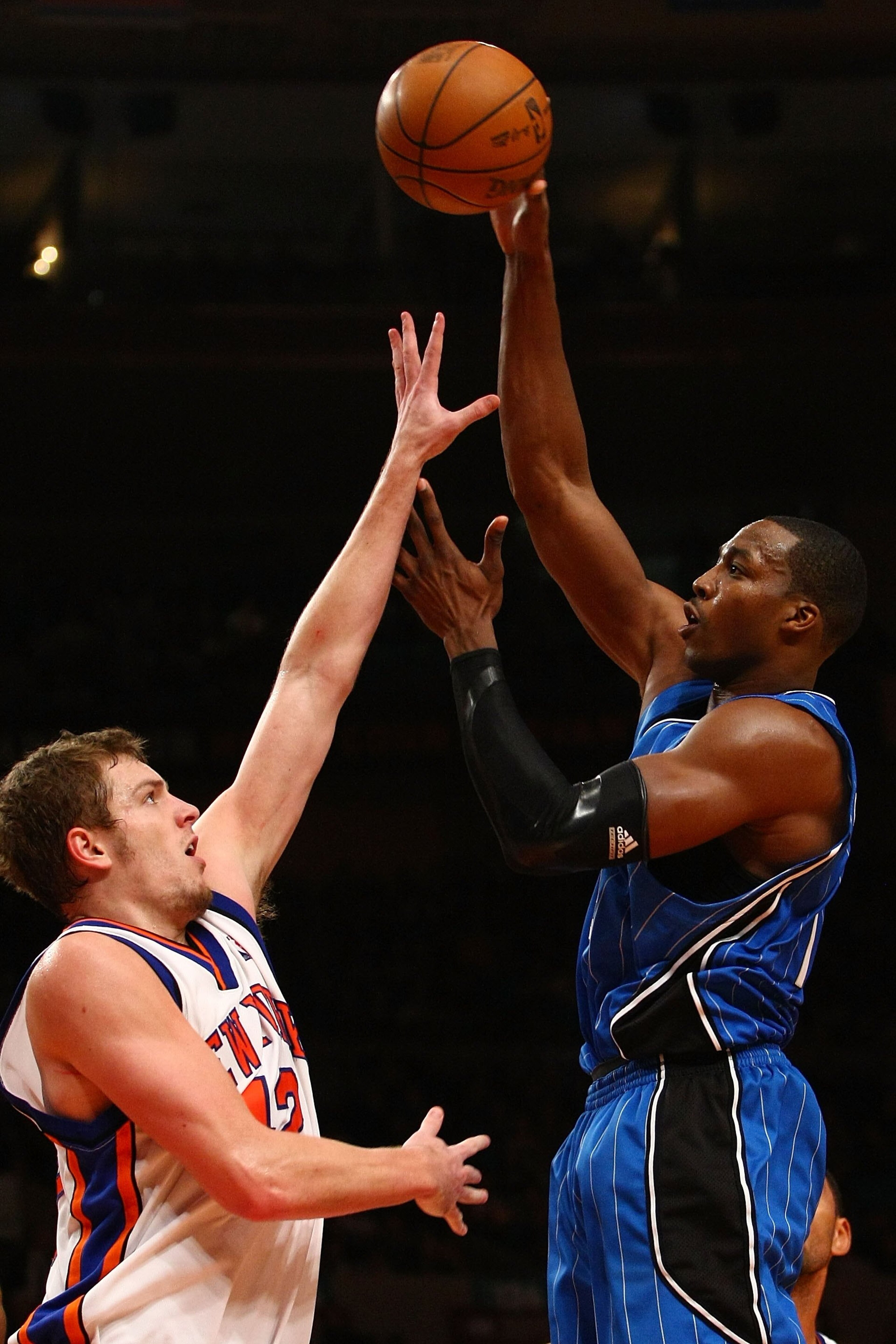 NEW YORK - NOVEMBER 29:  Dwight Howard #12 of the Orlando Magic shoots over David Lee #42 of the New York Knicks at Madison Square Garden November 29, 2009 in New York City. NOTE TO USER: User expressly acknowledges and agrees that, by downloading and/or