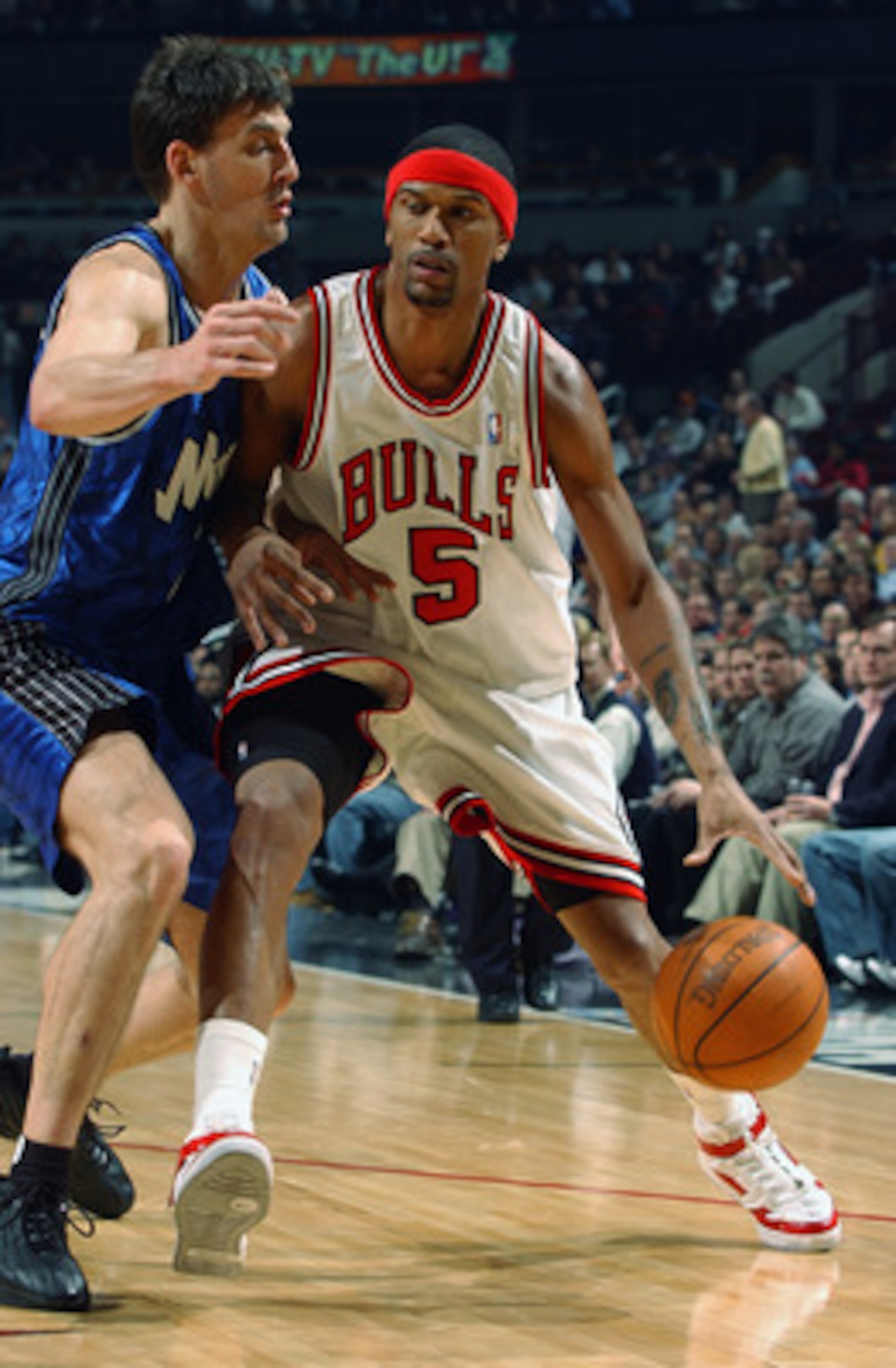 CHICAGO - MARCH 3:  Jalen Rose #5 of the Chicago Bulls drives around Gordan Giricek #7 of the Orlando Magic during the game at the United Center on March 3, 2003 in Chicago, Illinois.  The Magic won 104-89.  NOTE TO USER: User expressly acknowledges and a