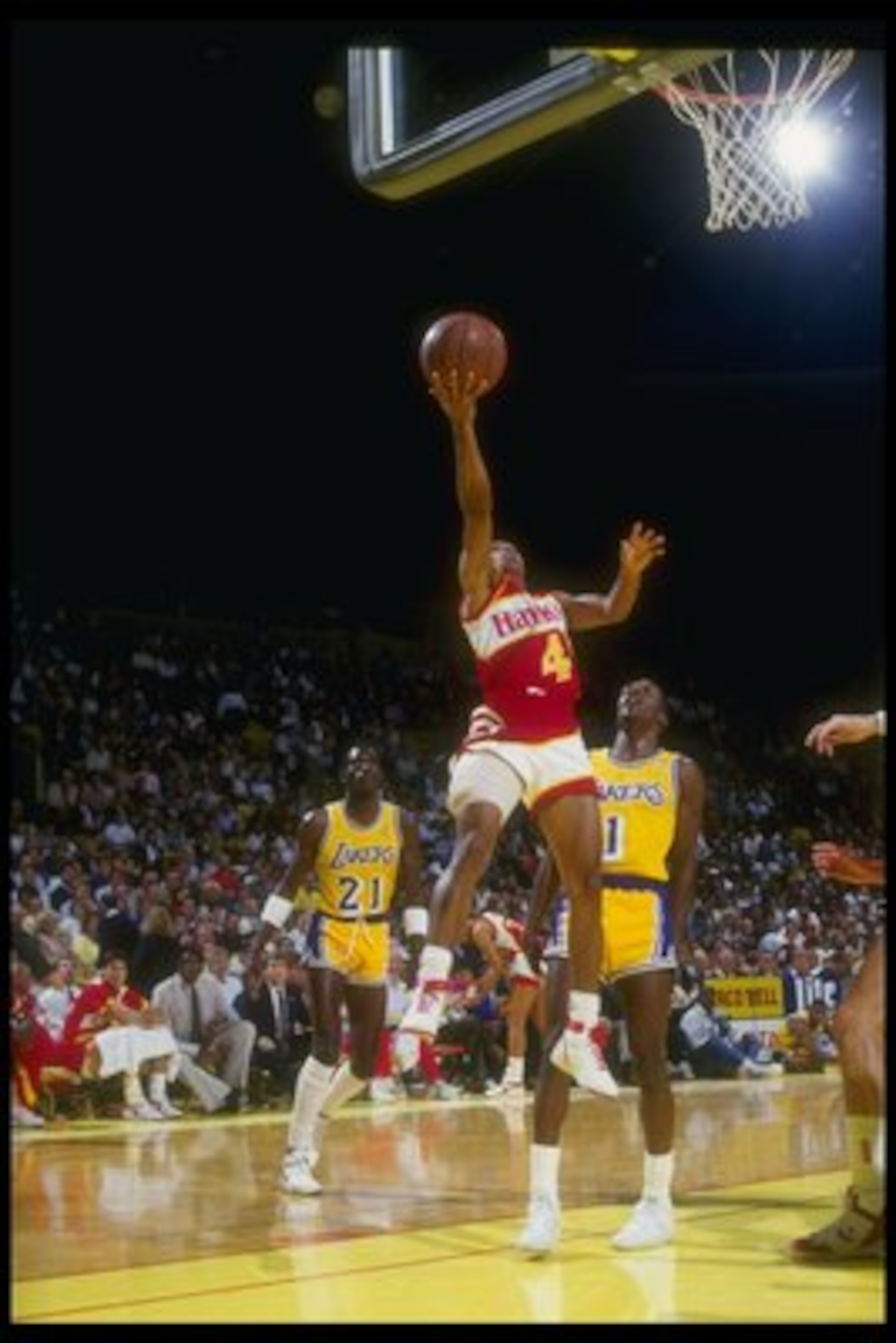 Point guard Anthony (Spud) Webb of the Atlanta Hawks goes to the hoop while the defenders of the Los Angeles Lakers look on during a game at The Forum in Inglewood, California