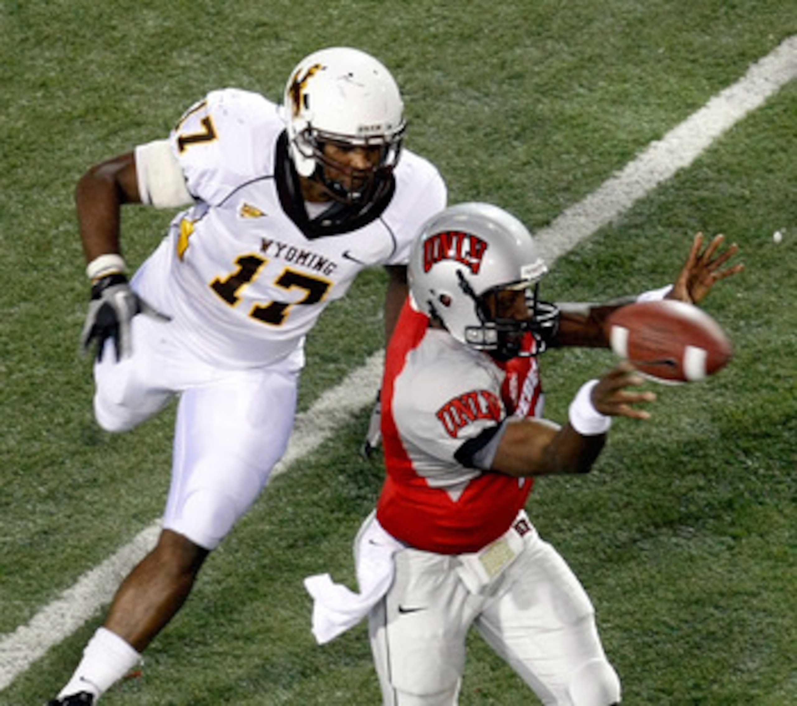 LAS VEGAS - NOVEMBER 13:  Quarterback Omar Clayton #2 of the UNLV Rebels throws under pressure from Keith Lewis #17 of the Wyoming Cowboys during their game at Sam Boyd Stadium November 13, 2010 in Las Vegas, Nevada. UNLV won 42-16.  (Photo by Ethan Mille
