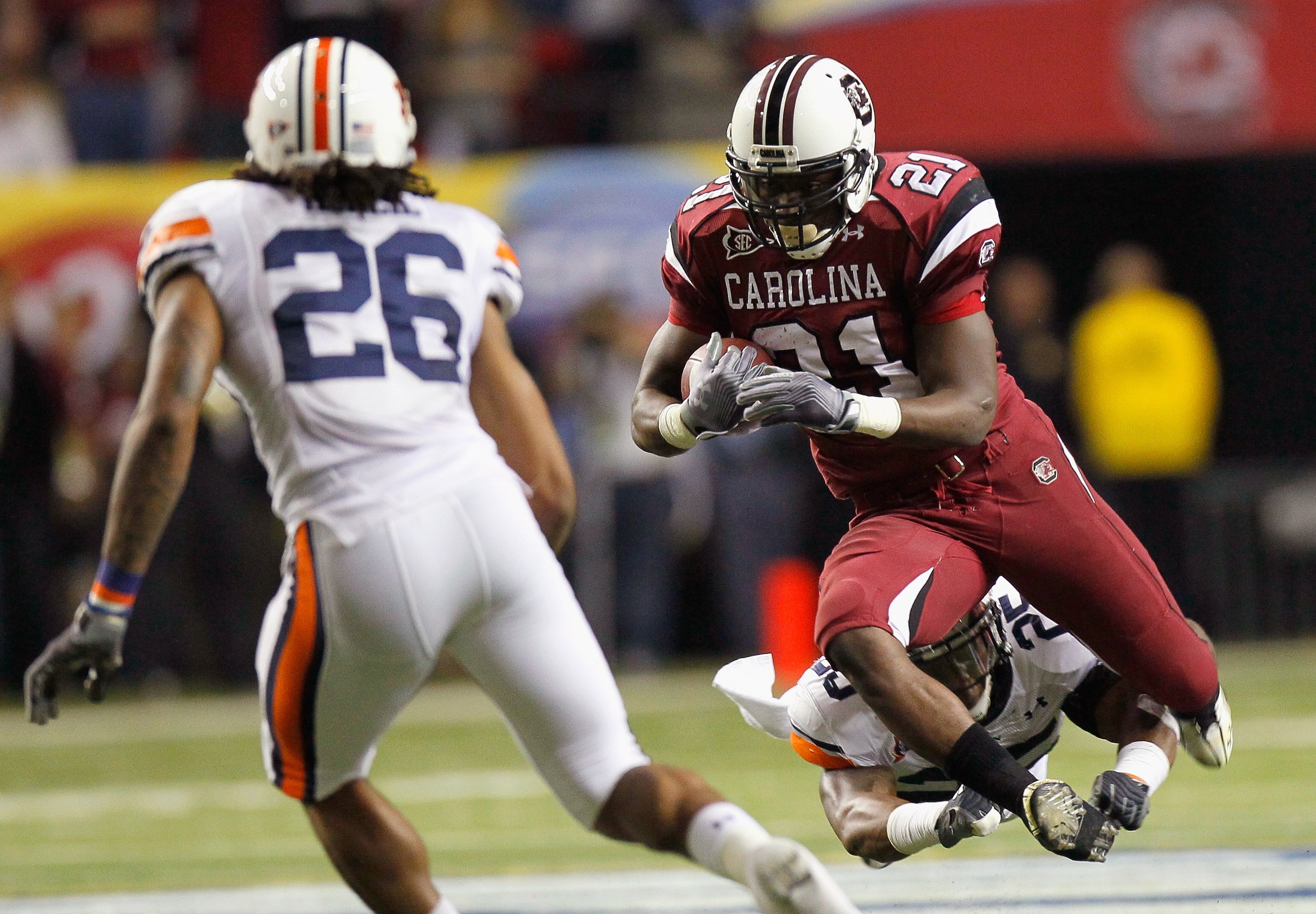 ATLANTA, GA - DECEMBER 04:  Marcus Lattimore #21 of the South Carolina Gamecocks is tackled by Daren Bates #25 of the Auburn Tigers during the 2010 SEC Championship at Georgia Dome on December 4, 2010 in Atlanta, Georgia.  (Photo by Kevin C. Cox/Getty Ima