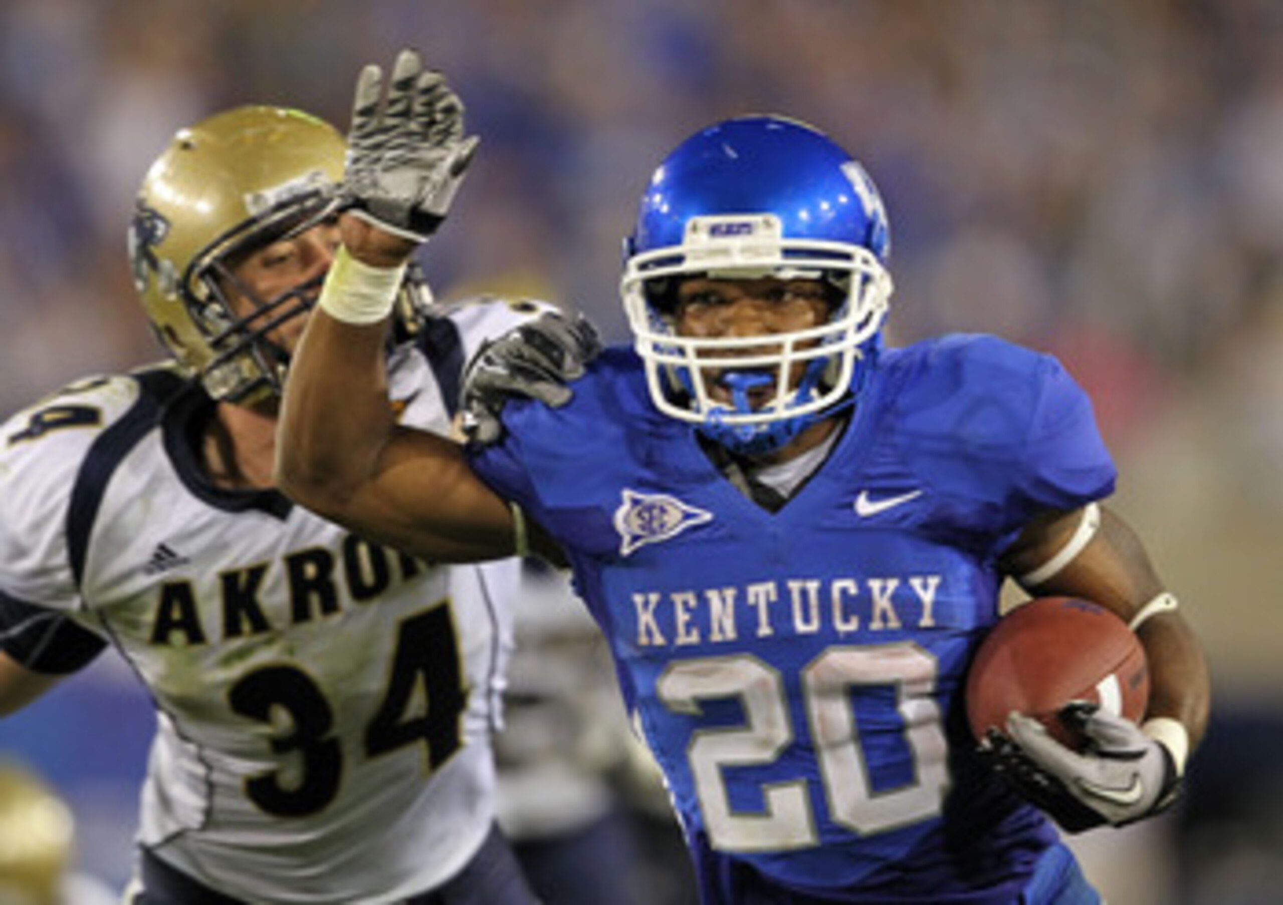 LEXINGTON, KY - SEPTEMBER 18:  Derrick Locke #20 of the Kentucky Wildcats runs for a touchdown while defended by Brian Wagner #34 of the Akron Zips during the game  at Commonwealth Stadium on September 18, 2010 in Lexington, Kentucky.  (Photo by Andy Lyon