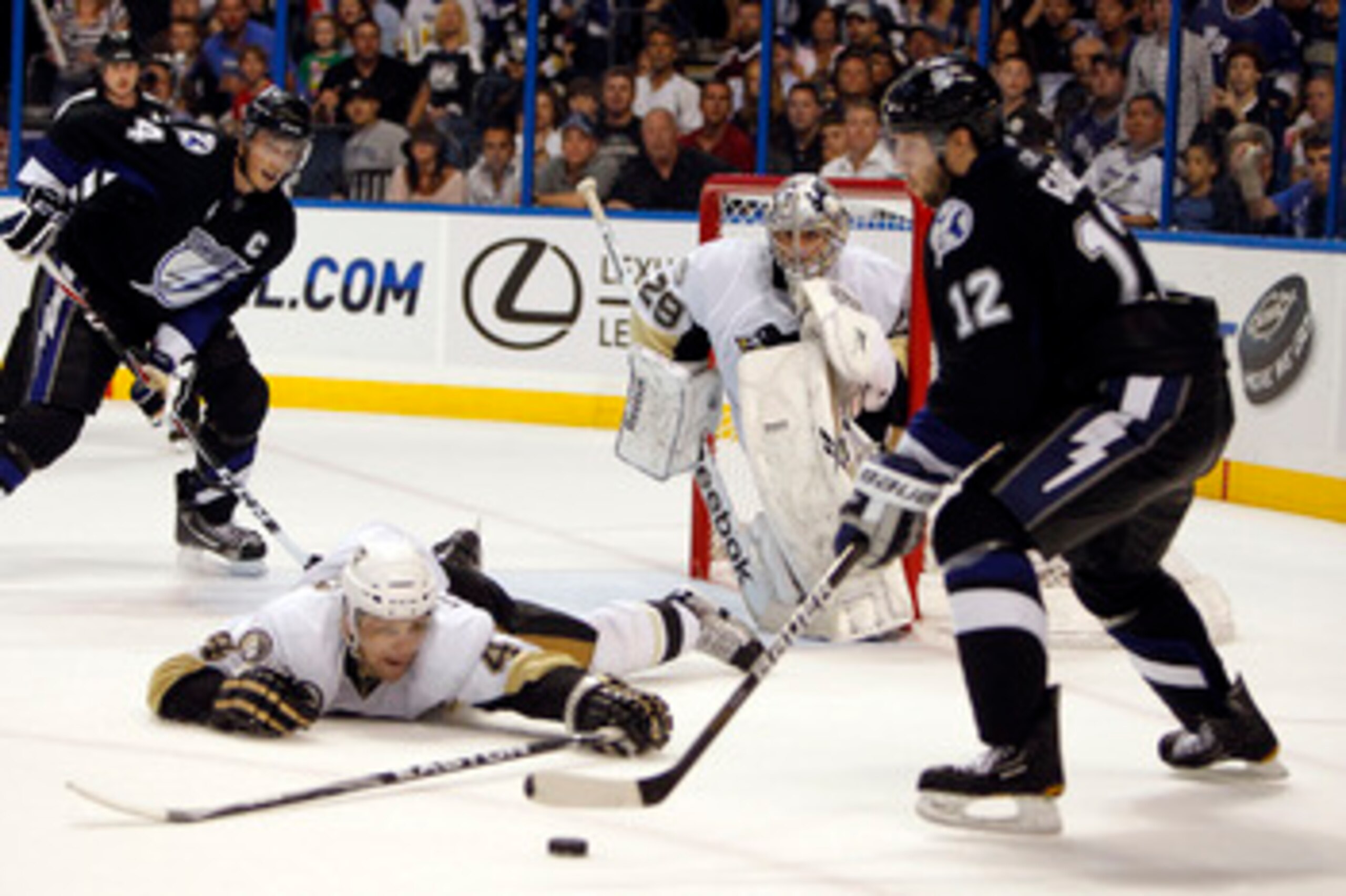 TAMPA, FL - APRIL 20: Goaltender Marc-Andre Fleury #29 of the Pittsburgh Penguins defends the net with the help of teammate Zbynek Michalek #4 against Simon Gagne #12 of the Tampa Bay Lightning in the first overtime period in Game Four of the Eastern Conf
