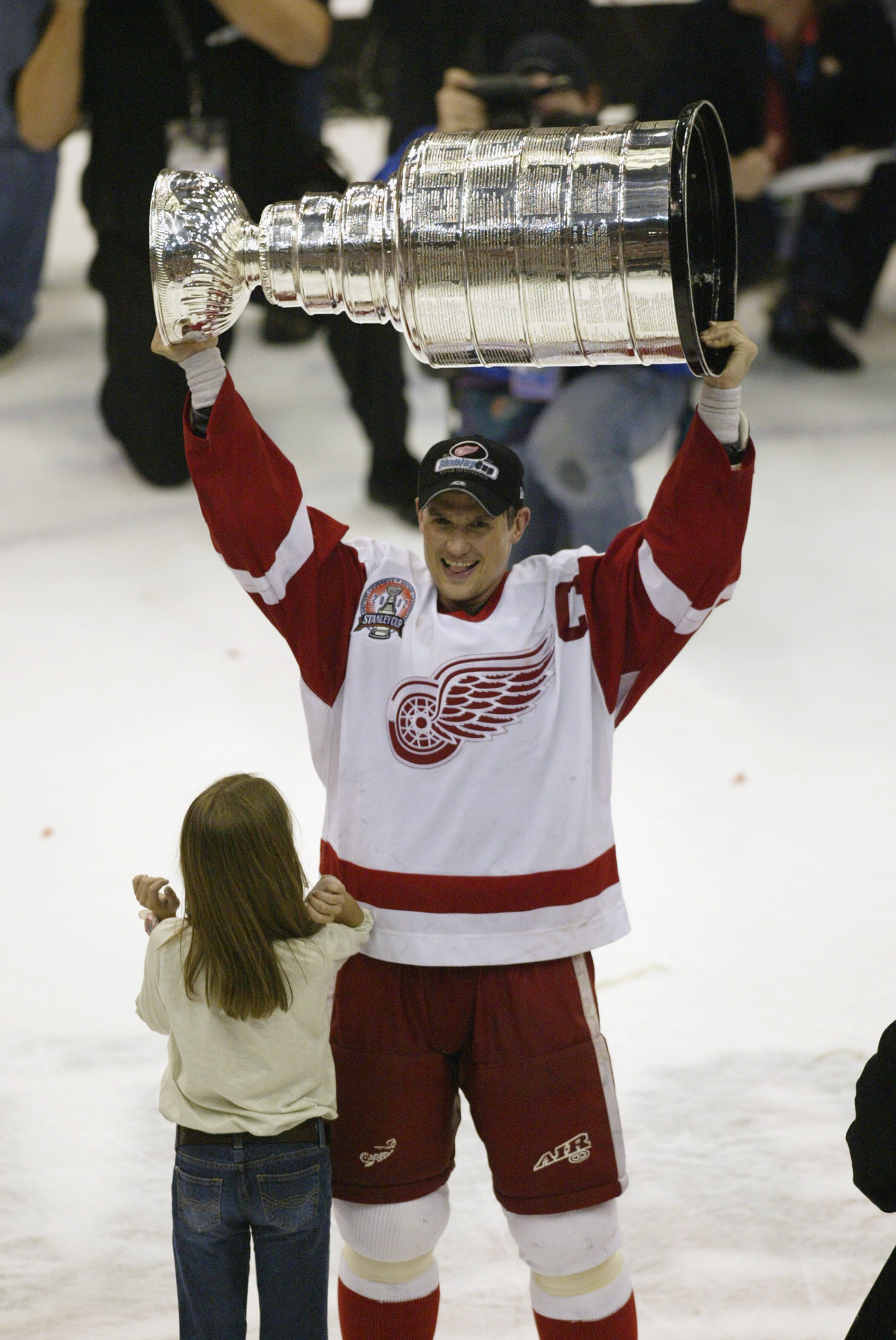 DETROIT, MI - JUNE 13:  Steve Yzerman #19 of the Detroit Red Wings and his daughter Isabella celebrate with the Stanley Cup trophy after defeating the Carolina Hurricanes during game 5 of the 2002 Stanley Cup Finals on June 13, 2002 at Joe Louis Arena in