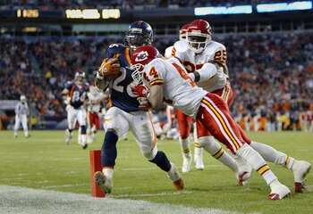 DENVER - DECEMBER 7: Running back Clinton Portis #26 of the Denver Broncos scores a touchdown despite a hit by cornerback Eric Warfield #44 of the Kansas City Chiefs in the fourth quarter December 7, 2003 at Invesco Field at Mile High in Denver, Colorado DENVER - DECEMBER 7: Running back Clinton Portis #26 of the Denver Broncos scores a touchdown despite a hit by cornerback Eric Warfield #44 of the Kansas City Chiefs in the fourth quarter December 7, 2003 at Invesco Field at Mile High in Denver, Colorado