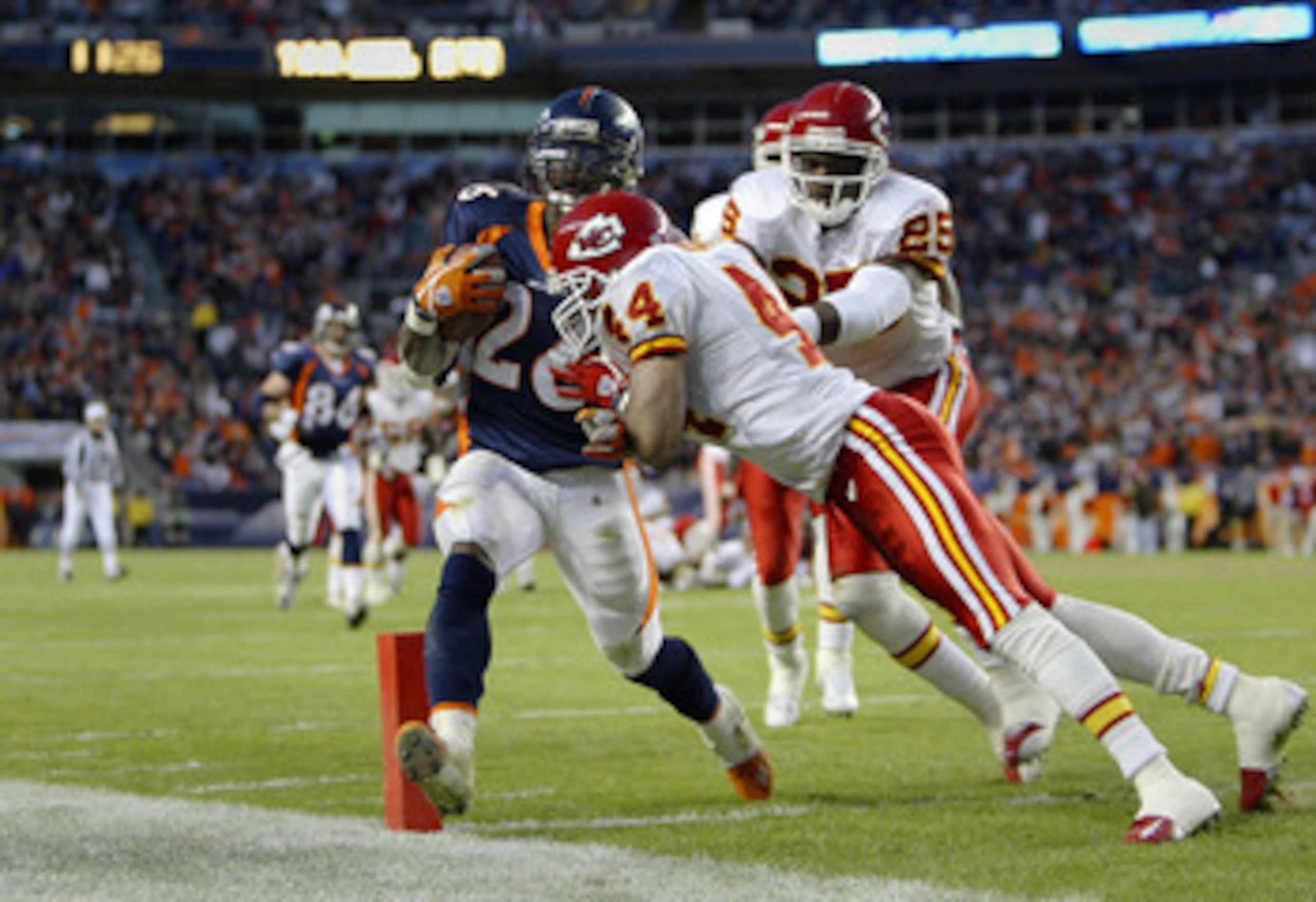 DENVER - DECEMBER 7: Running back Clinton Portis #26 of the Denver Broncos scores a touchdown despite a hit by cornerback Eric Warfield #44 of the Kansas City Chiefs in the fourth quarter December 7, 2003 at Invesco Field at Mile High in Denver, Colorado DENVER - DECEMBER 7: Running back Clinton Portis #26 of the Denver Broncos scores a touchdown despite a hit by cornerback Eric Warfield #44 of the Kansas City Chiefs in the fourth quarter December 7, 2003 at Invesco Field at Mile High in Denver, Colorado