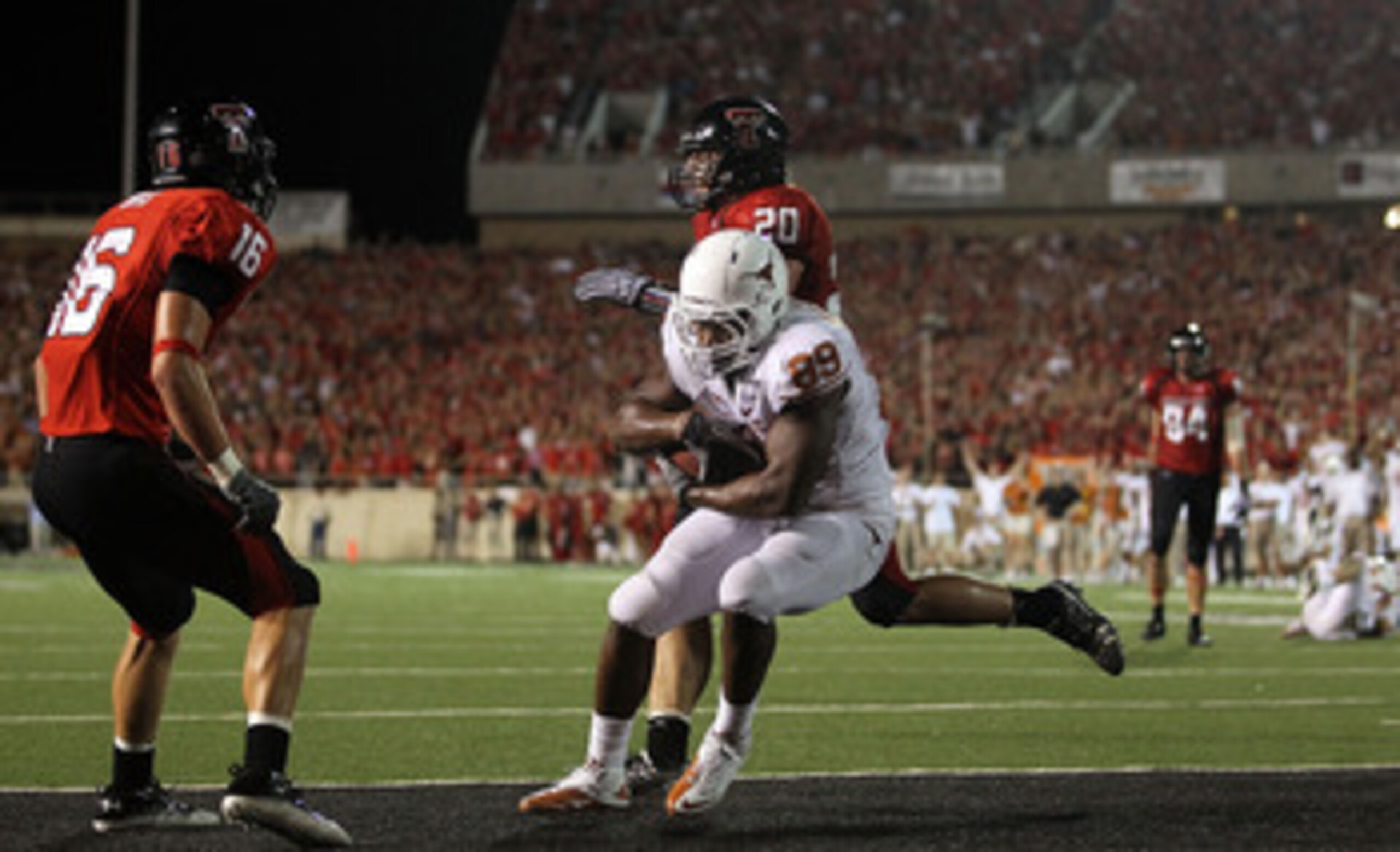 LUBBOCK, TX - SEPTEMBER 18:  Tight end Barrett Matthews #89 of the Texas Longhorns makes a touchdown passs reception against Bront Bird #20 and Cody Davis #16 of the Texas Tech Red Raiders in the fourth quarter at Jones AT&T Stadium on September 18, 2010 