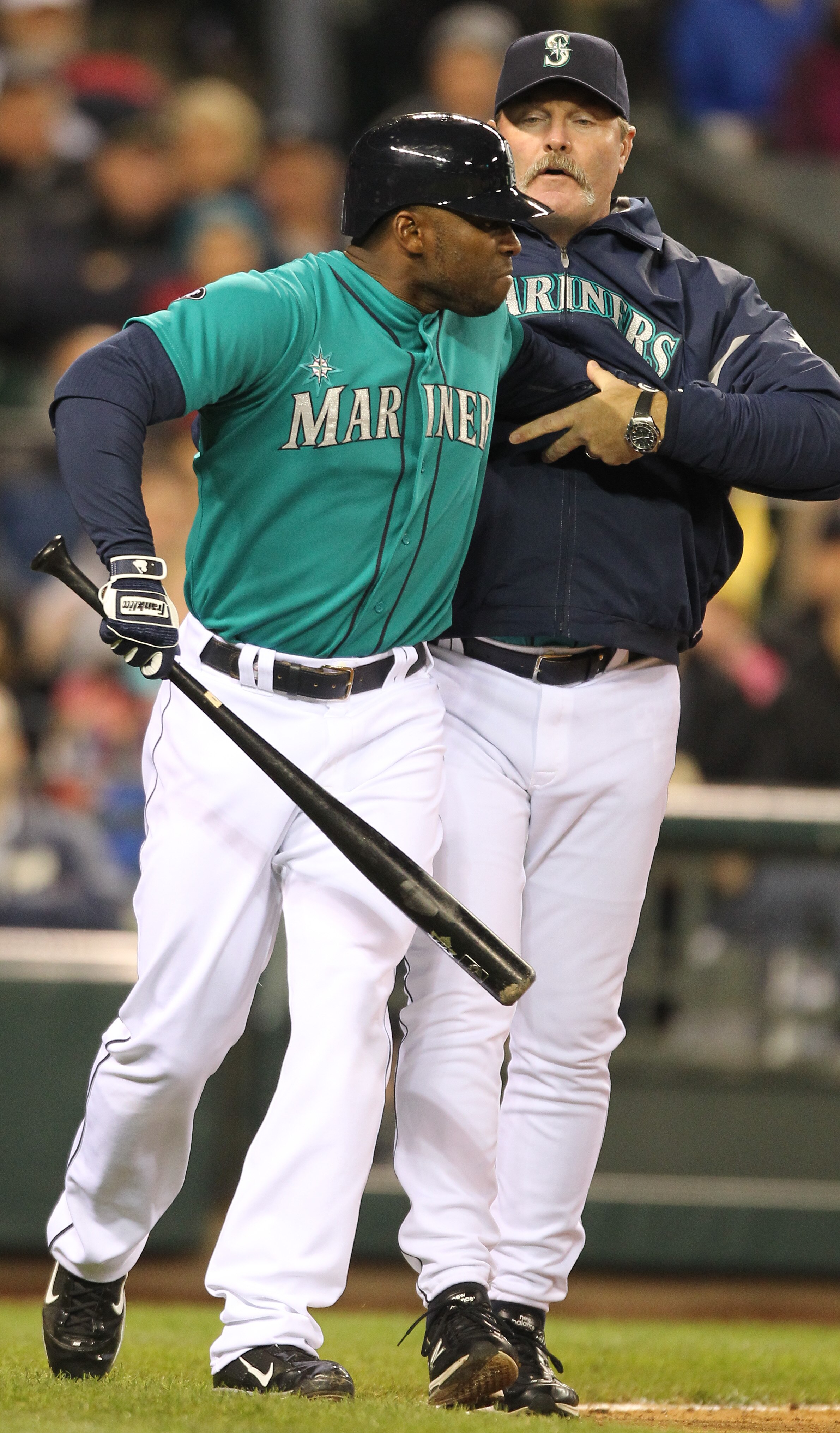 SEATTLE - MAY 06:  Milton Bradley #15 of the Seattle Mariners is restrained by manager Eric Wedge #22 after being ejected from the game against the Chicago White Sox at Safeco Field on May 6, 2011 in Seattle, Washington. The Mariners won 3-2. (Photo by Ot