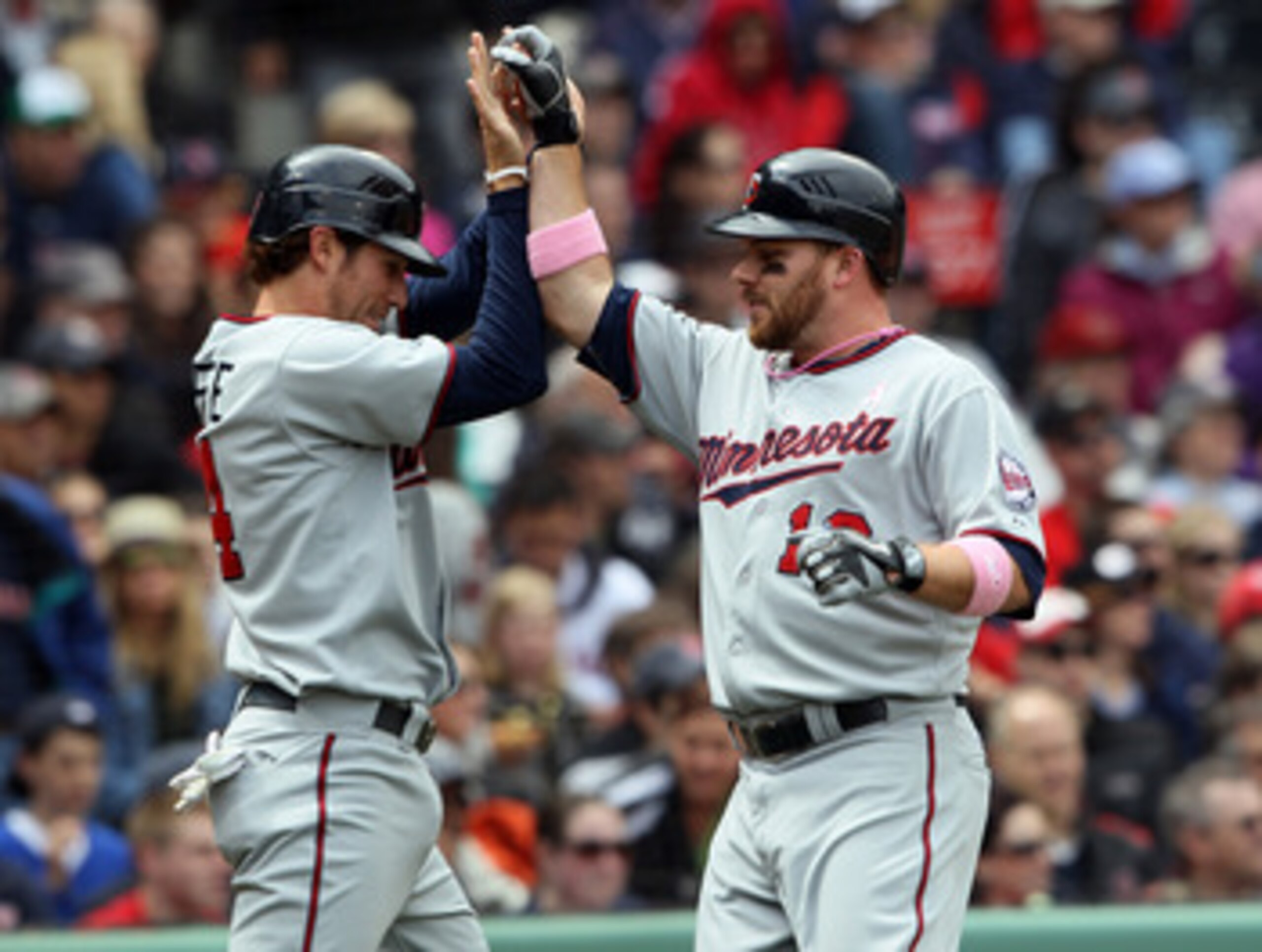 BOSTON, MA - MAY 08: Trevor Plouffe #24 and Jason Kubel #16 of the Minnesota Twins celebrate after they scored off a single by Danny Valencia in the first inning against the Boston Red Sox  on May 8, 2011 at Fenway Park in Boston, Massachusetts.  (Photo b