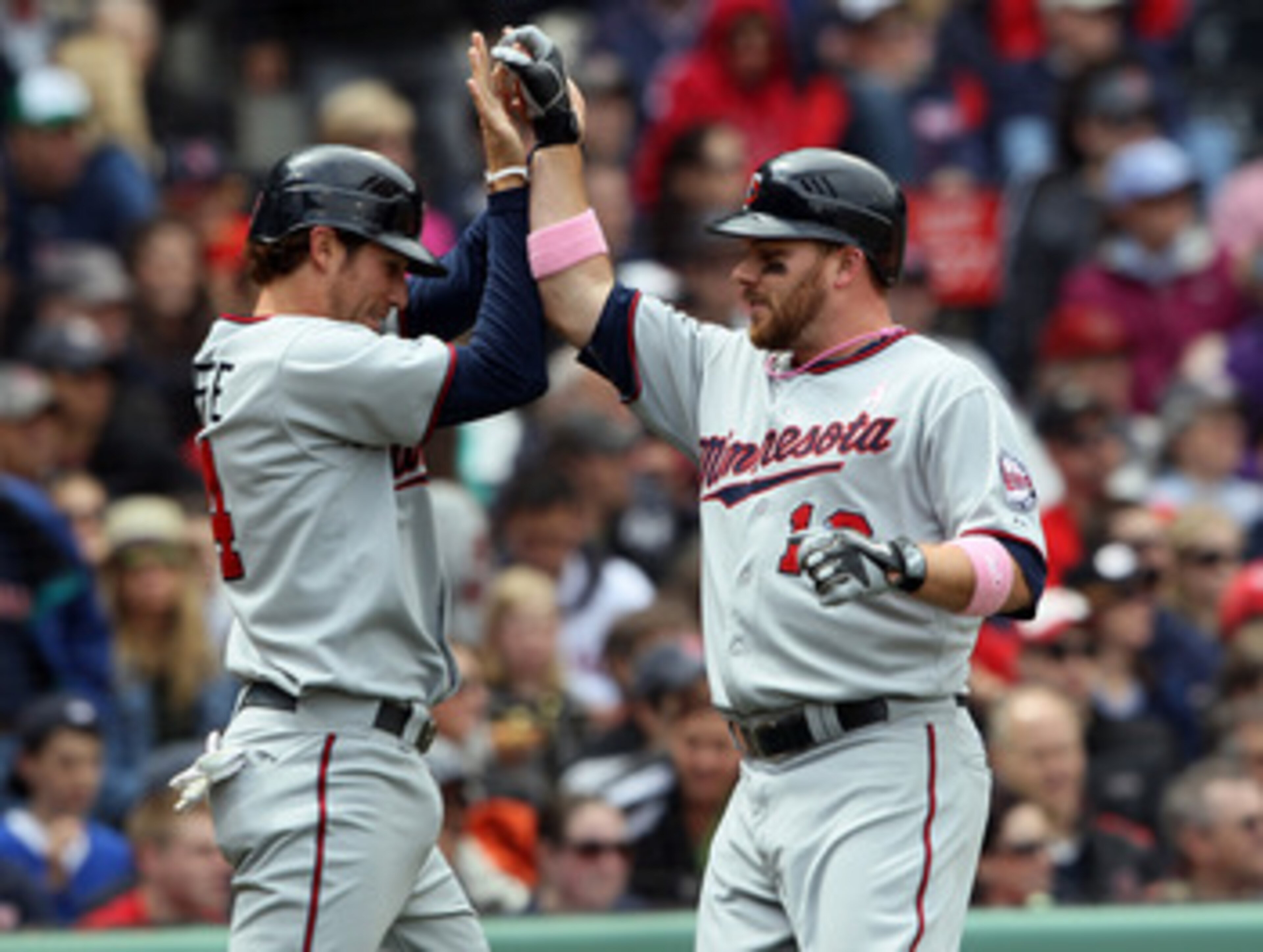 BOSTON, MA - MAY 08: Trevor Plouffe #24 and Jason Kubel #16 of the Minnesota Twins celebrate after they scored off a single by Danny Valencia in the first inning against the Boston Red Sox  on May 8, 2011 at Fenway Park in Boston, Massachusetts.  (Photo b