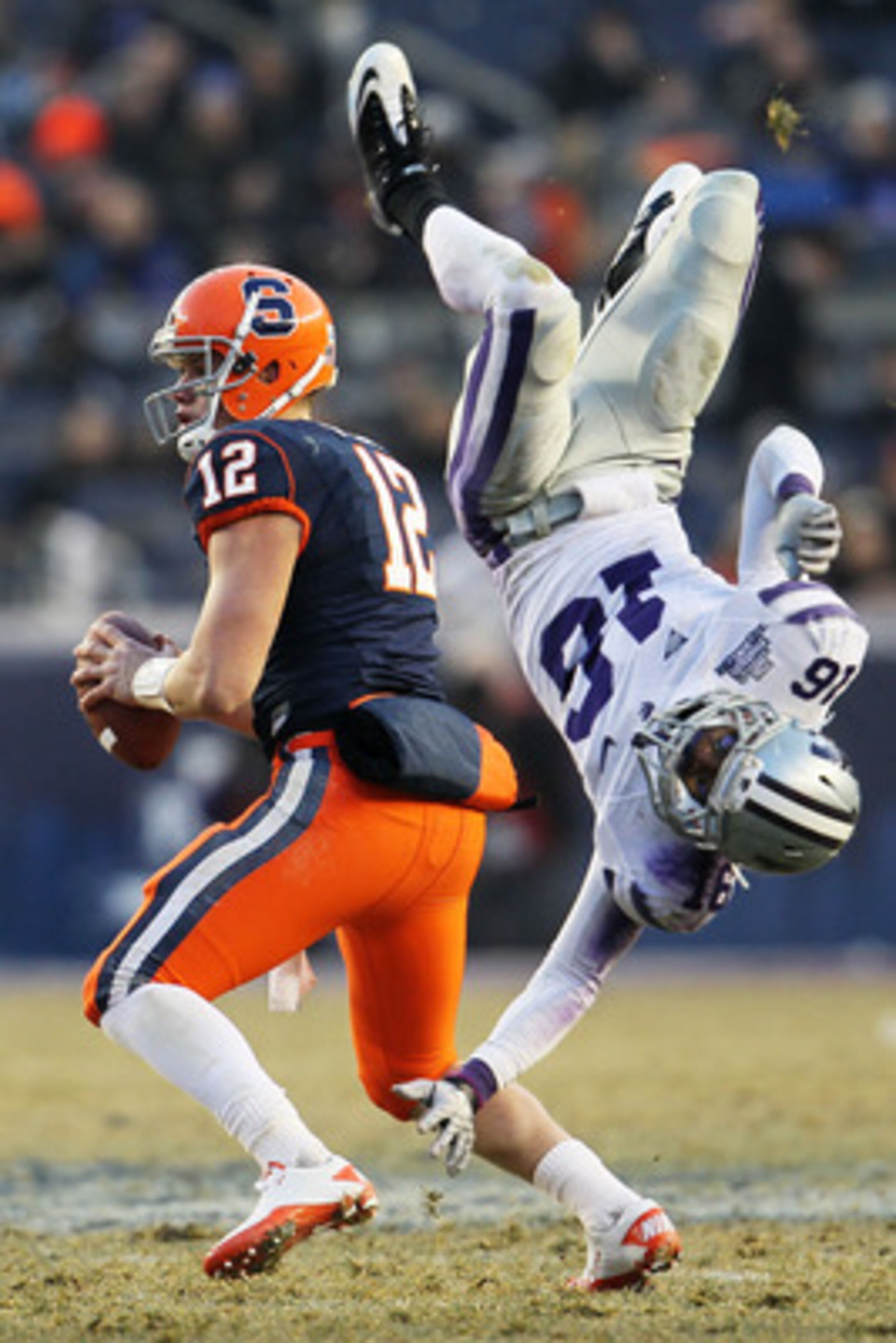NEW YORK, NY - DECEMBER 30: Quarterback Ryan Nassib #12 of the Syracuse Orange gets around a diving tackle by Terrence Sweeney #16 of the Kansas State Wildcats during the New Era Pinstripe Bowl at Yankee Stadium on December 30, 2010 in New York, New York.