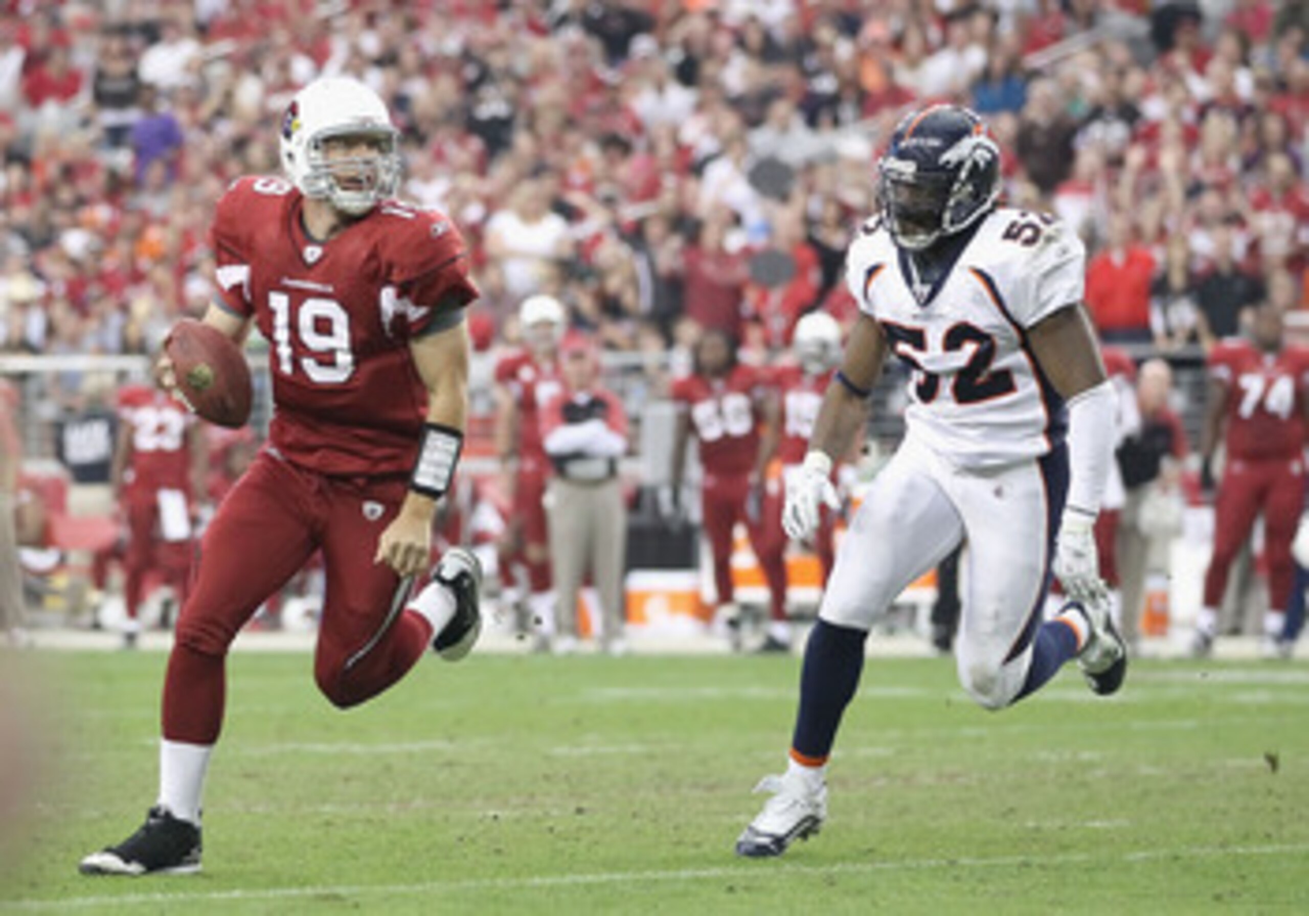 GLENDALE, AZ - DECEMBER 12:  Quarterback John Skelton #19 of the Arizona Cardinals scrambles with the football under pressure from Jason Hunter #52 of the Denver Broncos during the NFL game at the University of Phoenix Stadium on December 12, 2010 in Glen