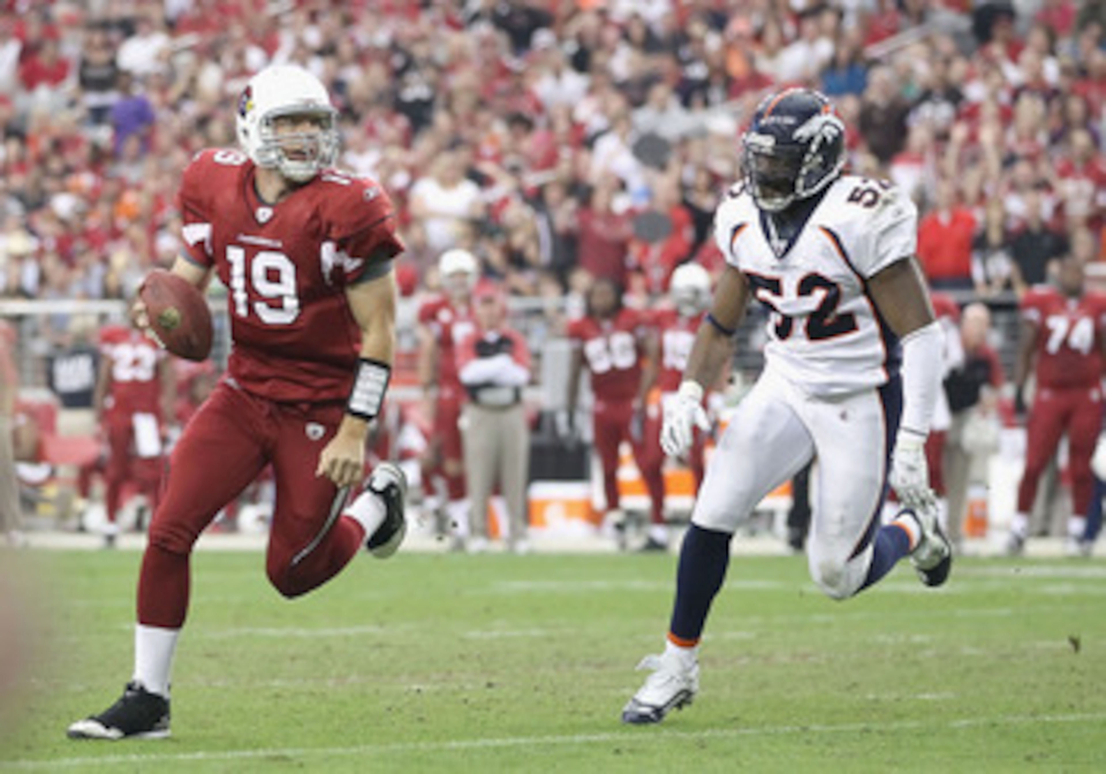 GLENDALE, AZ - DECEMBER 12:  Quarterback John Skelton #19 of the Arizona Cardinals scrambles with the football under pressure from Jason Hunter #52 of the Denver Broncos during the NFL game at the University of Phoenix Stadium on December 12, 2010 in Glen