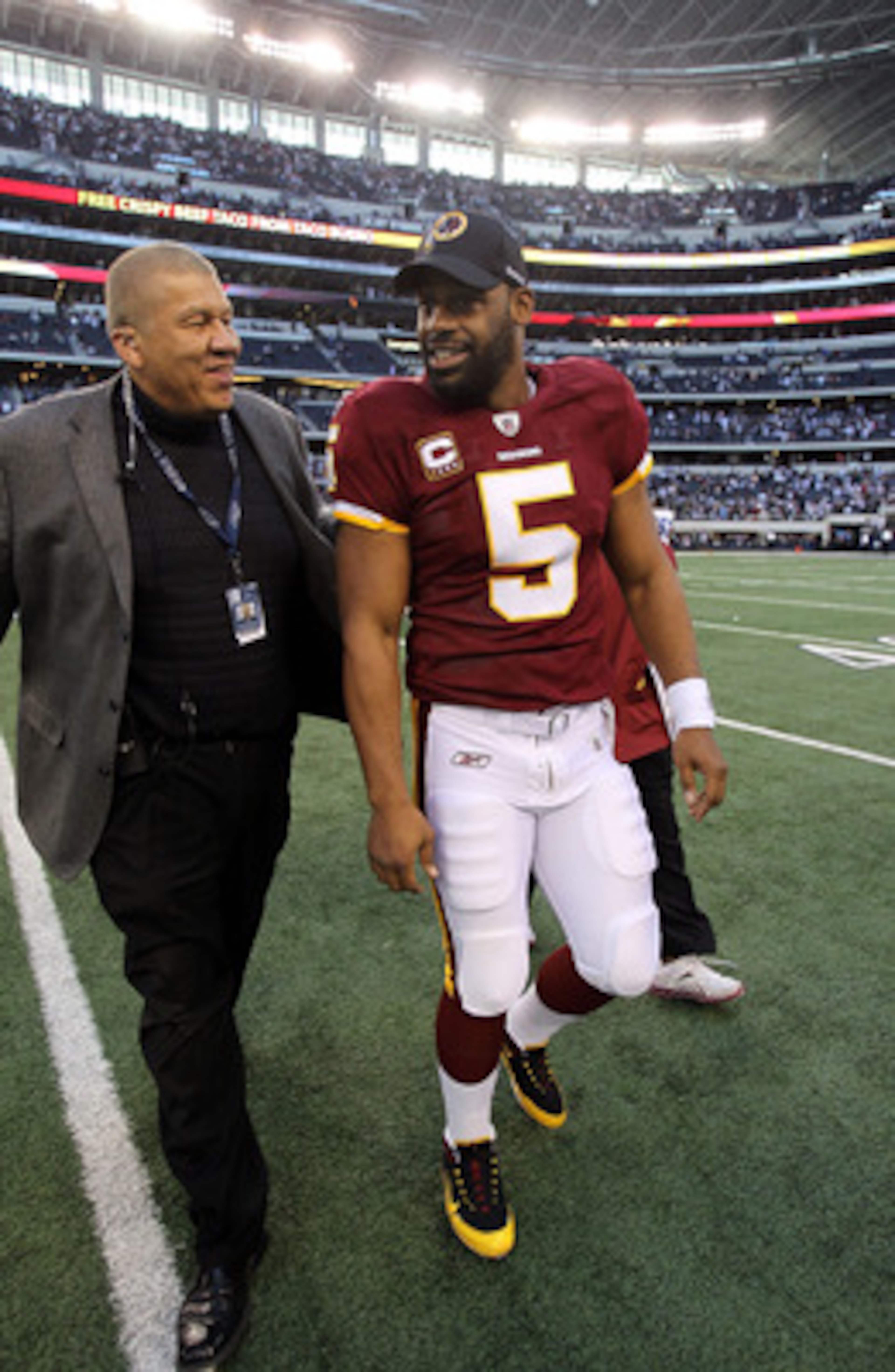 ARLINGTON, TX - DECEMBER 19:  Quarterback Donovan McNabb #5 of the Washington Redskins walks off the field after a loss against the Dallas Cowboys at Cowboys Stadium on December 19, 2010 in Arlington, Texas.  (Photo by Ronald Martinez/Getty Images)