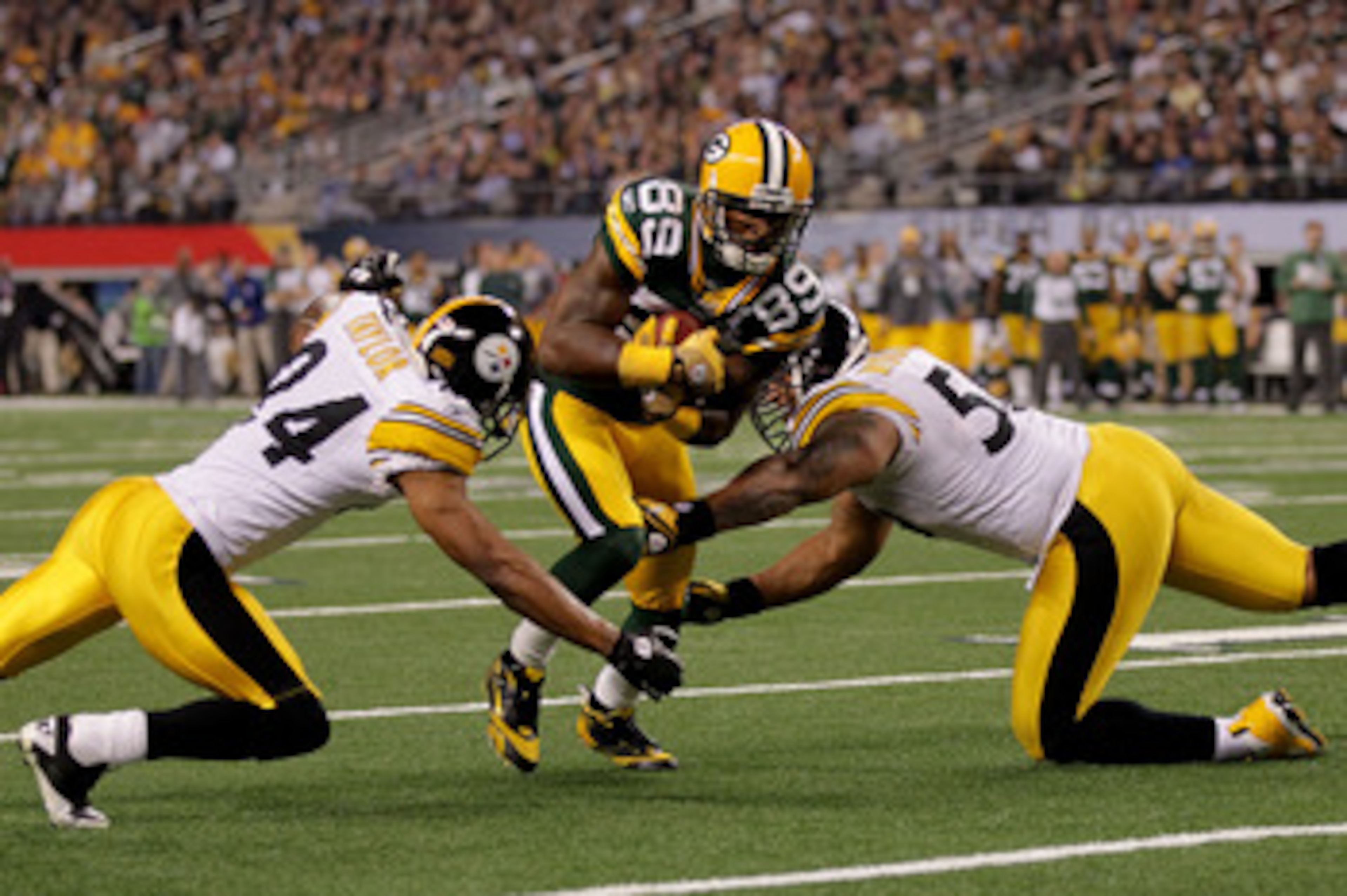 ARLINGTON, TX - FEBRUARY 06:  James Jones #89 of the Green Bay Packers tries to avoid the tackle of LaMarr Woodley #56 and Ike Taylor #24 of the Pittsburgh Steelers and during Super Bowl XLV at Cowboys Stadium on February 6, 2011 in Arlington, Texas.  (Ph