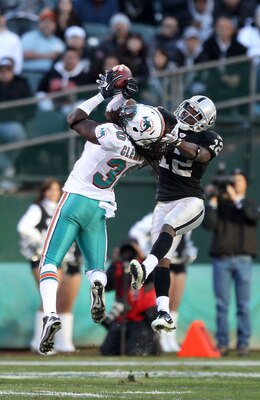 OAKLAND, CA - NOVEMBER 28:  Jacoby Ford #12 of the Oakland Raiders catches the ball while defended by Chris Clemons #30 of the Miami Dolphins at Oakland-Alameda County Coliseum on November 28, 2010 in Oakland, California.  (Photo by Ezra Shaw/Getty Images