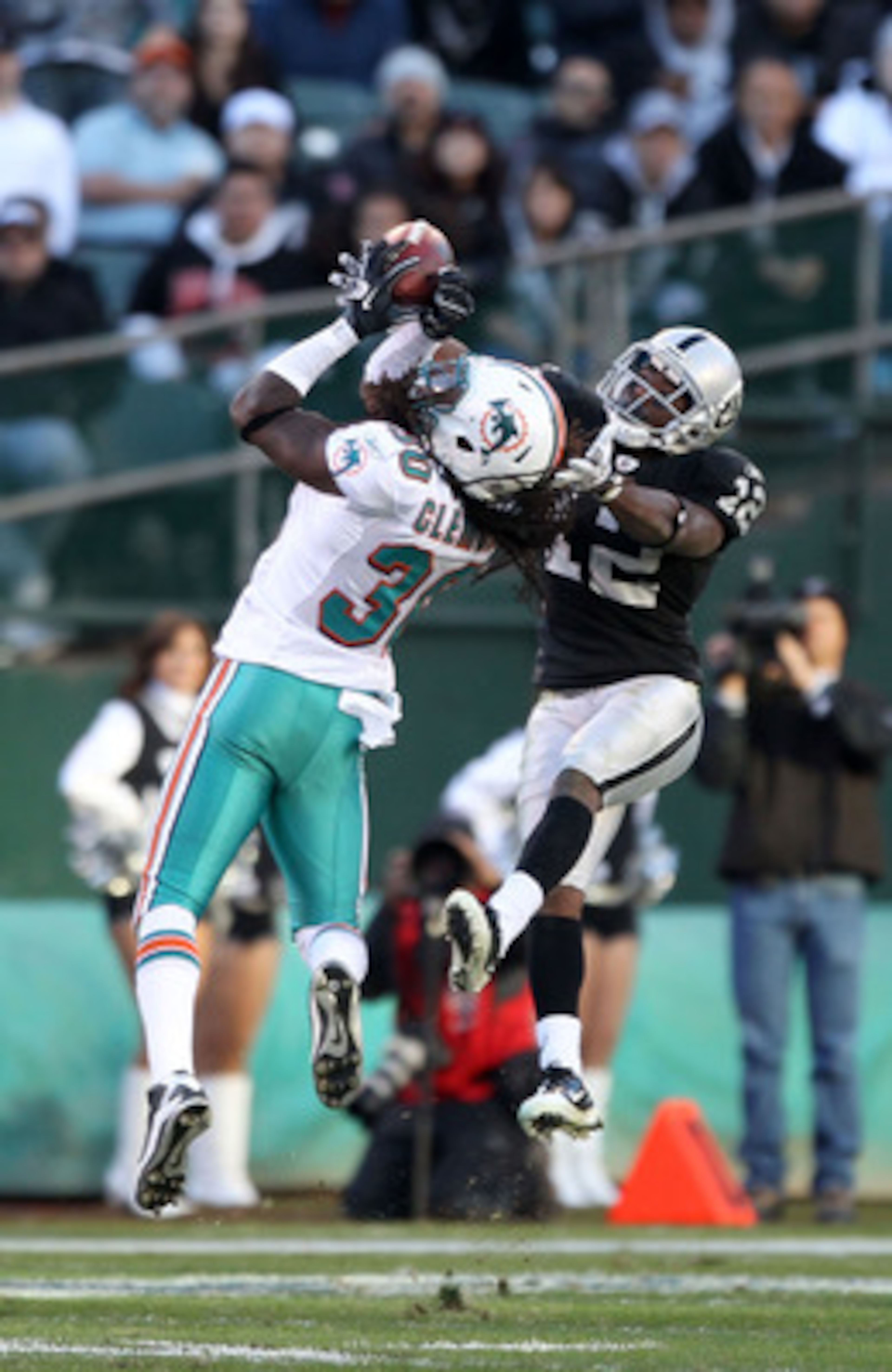 OAKLAND, CA - NOVEMBER 28:  Jacoby Ford #12 of the Oakland Raiders catches the ball while defended by Chris Clemons #30 of the Miami Dolphins at Oakland-Alameda County Coliseum on November 28, 2010 in Oakland, California.  (Photo by Ezra Shaw/Getty Images