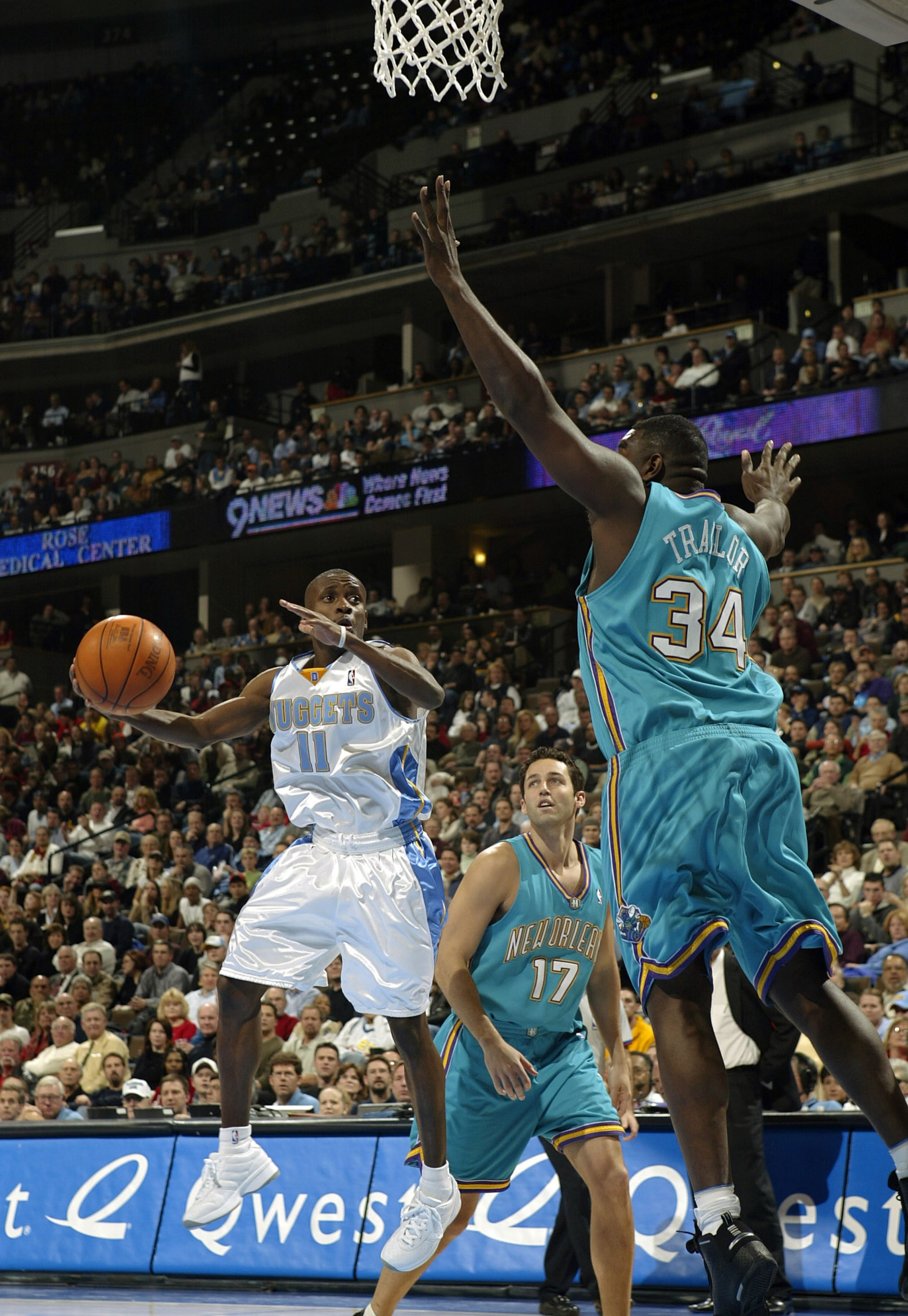 DENVER - DECEMBER 16:  Earl Boykins #11 of the Denver Nuggets weaves his way around Robert Traylor #34 of the New Orleans Hornets in the second half December 16, 2003 at the Pepsi Center in Denver, Colorado. The Nuggets won 116-94. NOTE TO USER: User expr