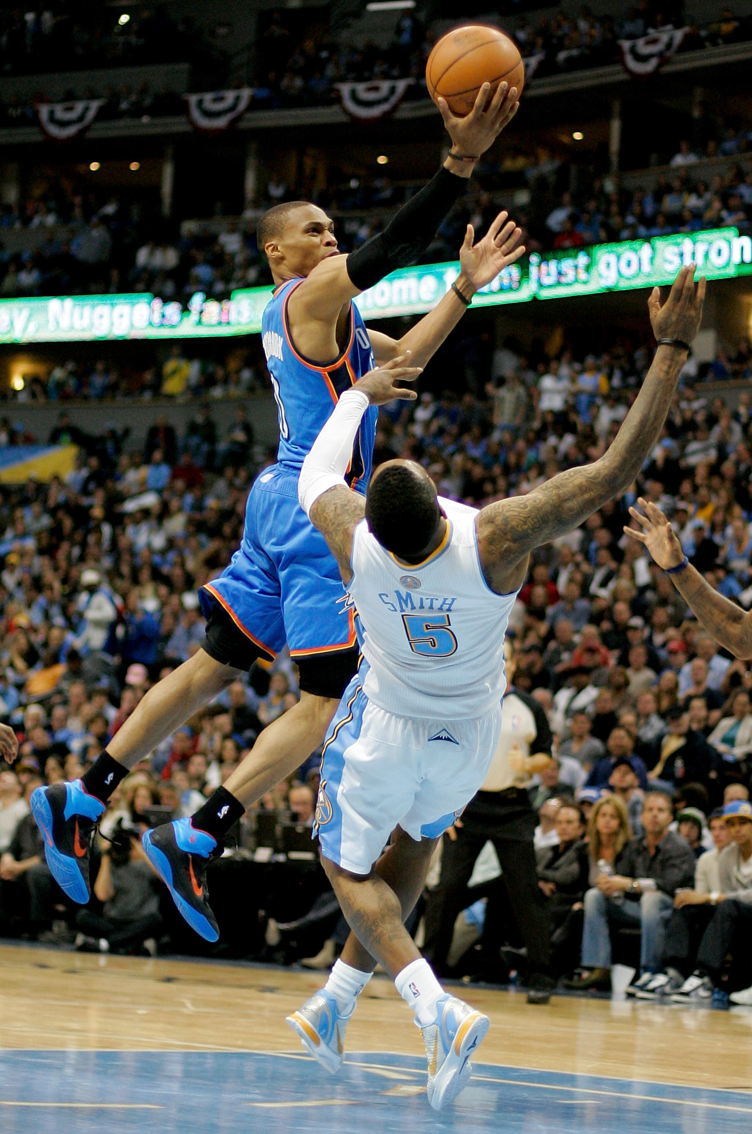 DENVER, CO - APRIL 25:  Russell Westbrook #0 of the Oklahoma City Thunder lays the ball up over a falling J.R. Smith #5 of the Denver Nuggets in Game Four of the Western Conference Quarterfinals in the 2011 NBA Playoffs at Pepsi Center on April 25, 2011 i