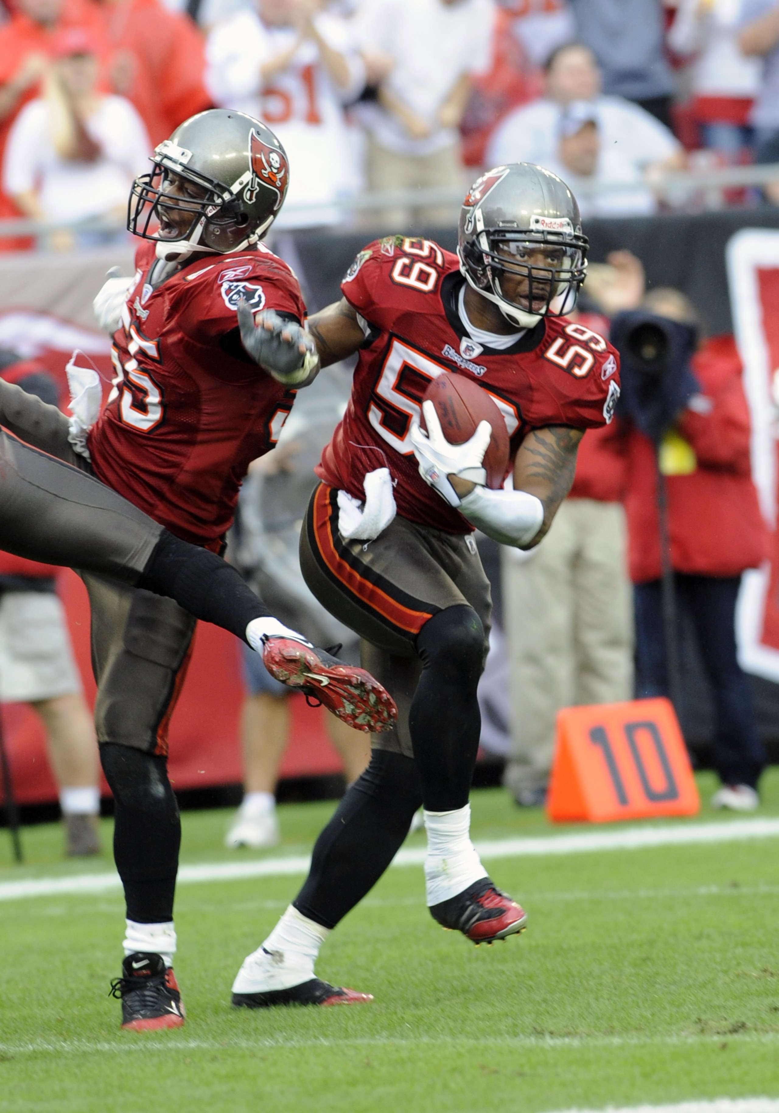 TAMPA, FL - NOVEMBER 30: Linebackers Cato June #59 and Derrick Brooks #55 of the Tampa Bay Buccaneers celebrate an interception against the New Orleans Saints at Raymond James Stadium on November 30, 2008 in Tampa, Florida.  (Photo by Al Messerschmidt/Get