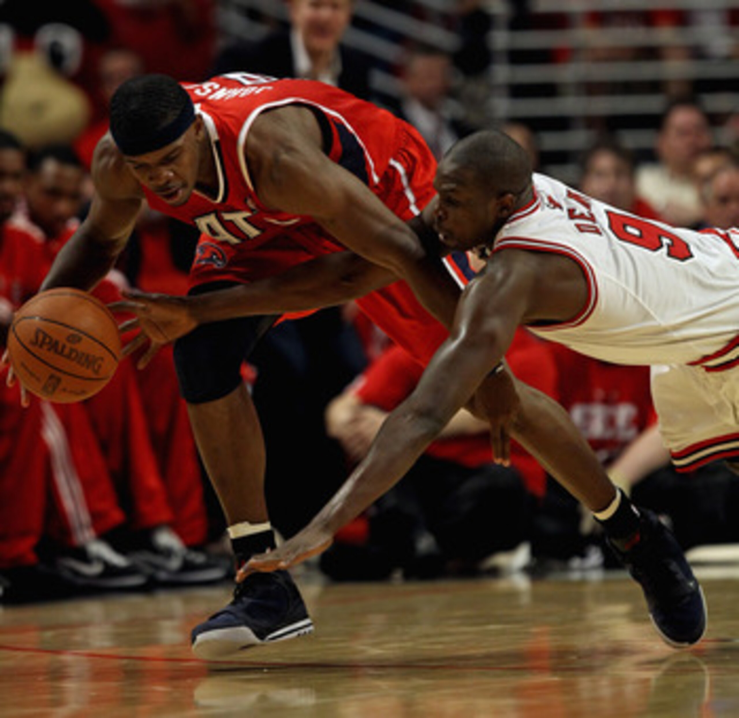 CHICAGO, IL - MAY 10: Loul Deng #9 of the Chicago Bulls dives for the ball held by Joe Johnson #2 of the Atlanta Hawks in Game Five of the Eastern Conference Semifinals in the 2011 NBA Playoffs at the United Center on May 10, 2011 in Chicago, Illinois. Th