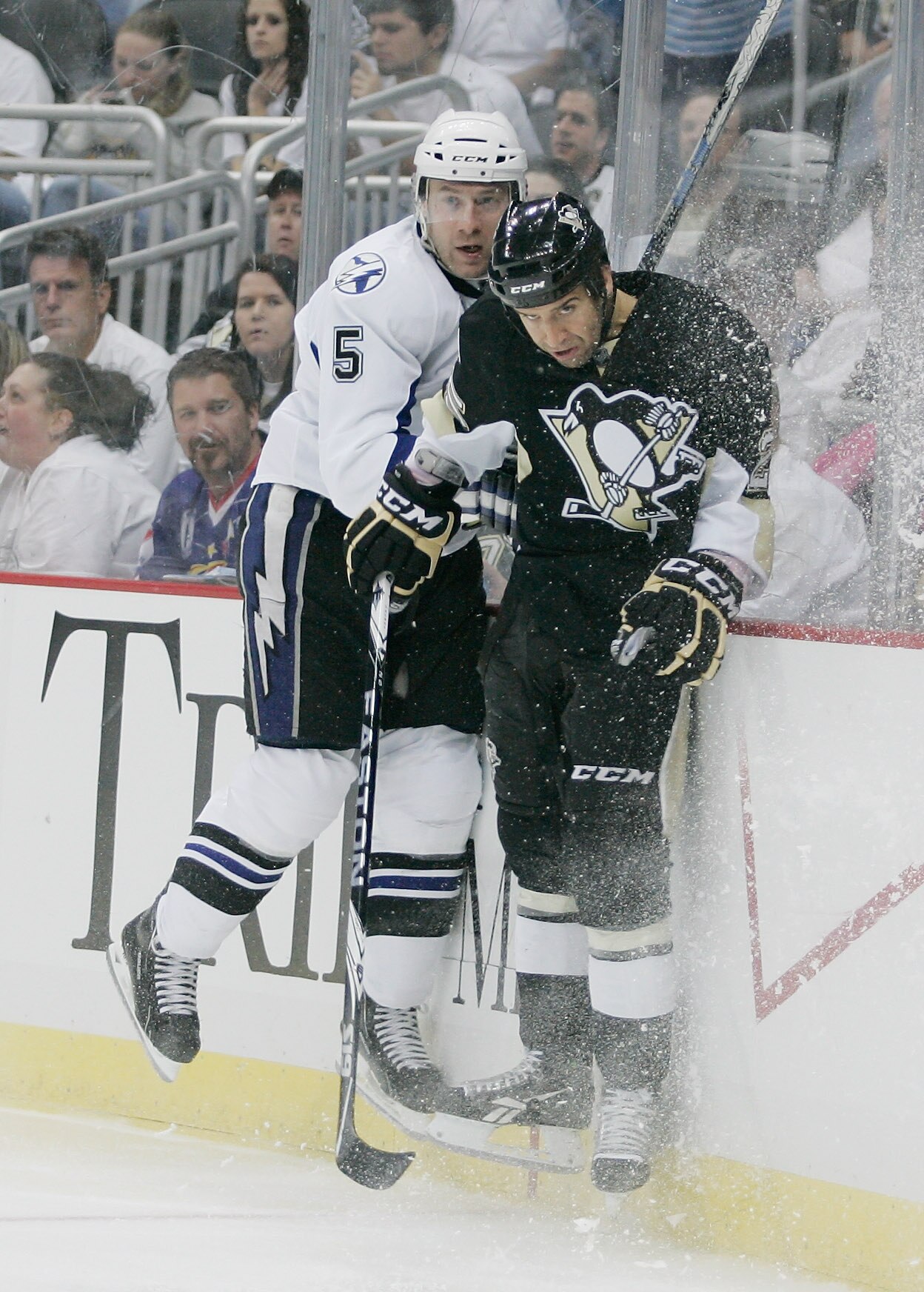 PITTSBURGH, PA - APRIL 15:  Mattias Ohlund #5 of the Tampa Bay Lightning crashes into the boards with Maxime Talbot #25 of the Pittsburgh Penguins during Game Two of the Eastern Conference Quarterfinals during the 2011 NHL Stanley Cup Playoffs at Consol E