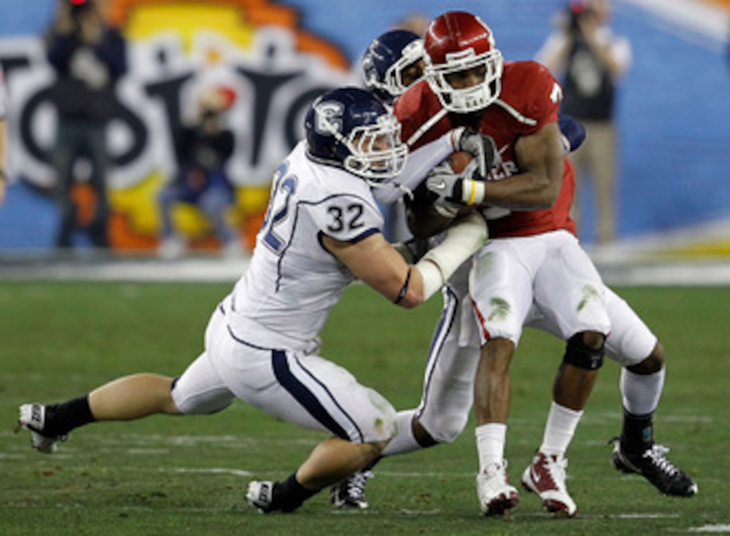 GLENDALE, AZ - JANUARY 01:  DeMarco Murray #7 of the Oklahoma Sooners runs the ball as Scott Lutrus #32 of the Connecticut Huskies attempts to take it away in the first half during the Tostitos Fiesta Bowl at the Universtity of Phoenix Stadium on January