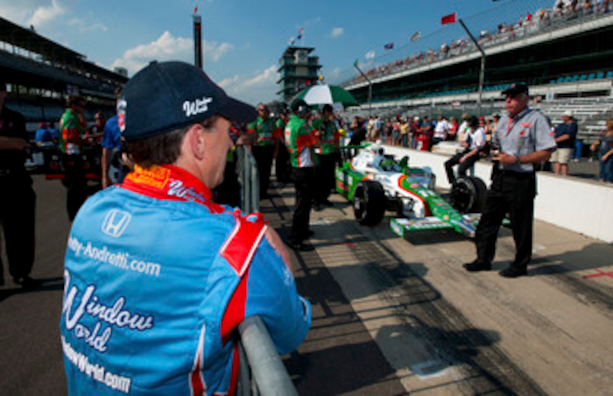 INDIANAPOLIS - MAY 23:  John Andretti driver of the #43 Richard Petty/Andretti Autosport Dallara Honda looks on as the #11 Andretti Autosports Dallara Honda of Tony Kanaan of Brazil is rolled in pit lane for a qualifying attempt during Bump Day qualifying