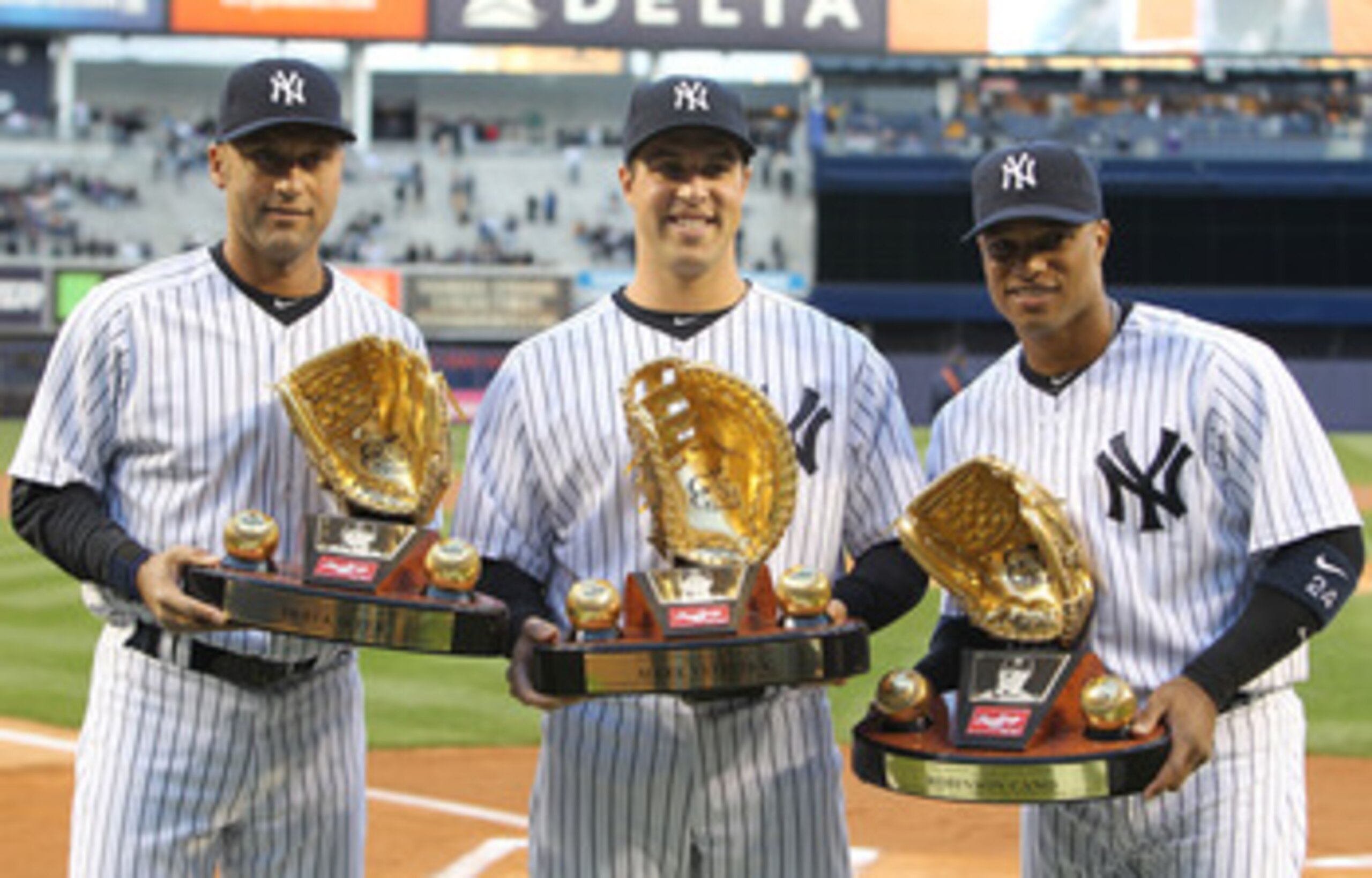 NEW YORK, NY - APRIL 05: (L-R) Derek Jeter #2, Mark Teixeira #25 and Robinson Cano #24 of the New York Yankees pose with their Gold Glove Awards prior to their game against the Minnesota Twins at Yankee Stadium on April 5, 2011 in the Bronx borough of New