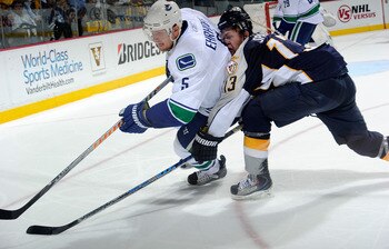 NASHVILLE, TN - MAY 09:  Christian Ehrhoff #5 of the Vancouver Canucks is hit by Nick Spaling #13 of the Nashville Predators in Game Six of the Western Conference Semifinals during the 2011 NHL Stanley Cup Playoffs at the Bridgestone Arena on May 9, 2011 