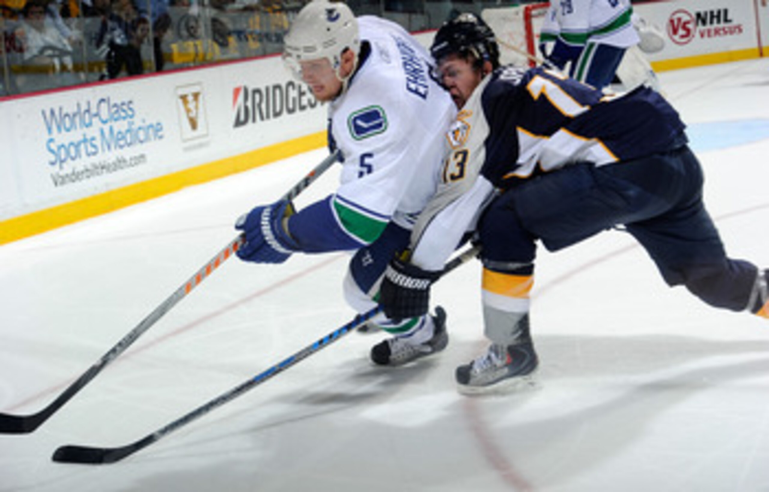 NASHVILLE, TN - MAY 09:  Christian Ehrhoff #5 of the Vancouver Canucks is hit by Nick Spaling #13 of the Nashville Predators in Game Six of the Western Conference Semifinals during the 2011 NHL Stanley Cup Playoffs at the Bridgestone Arena on May 9, 2011 
