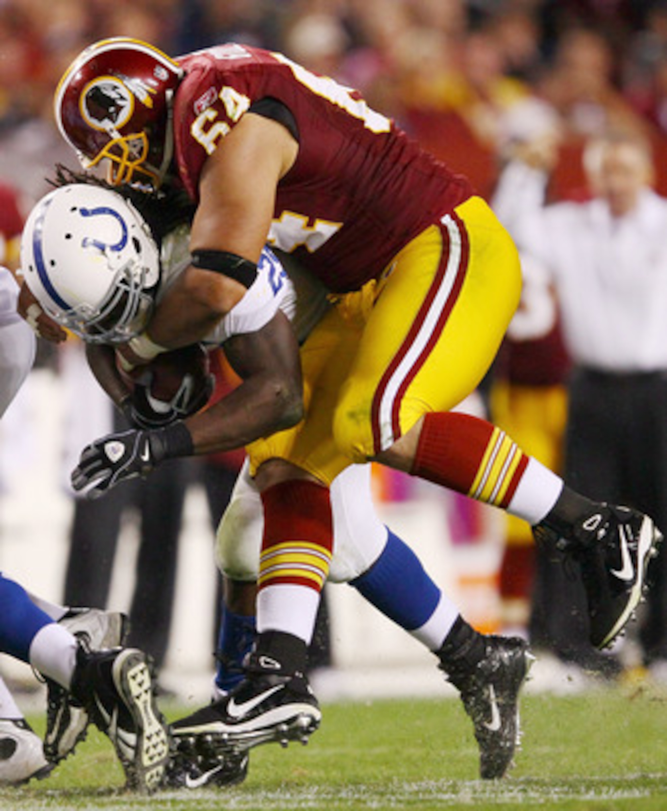 LANDOVER, MD - OCTOBER 17:  Running back Joseph Addai #29 of the Indianapolis Colts is tackled by Kedric Golston #64 of the Washington Redskins at FedEx Field on October 17, 2010 in Landover, Maryland. The Colts won the game 27-24.  (Photo by Win McNamee/