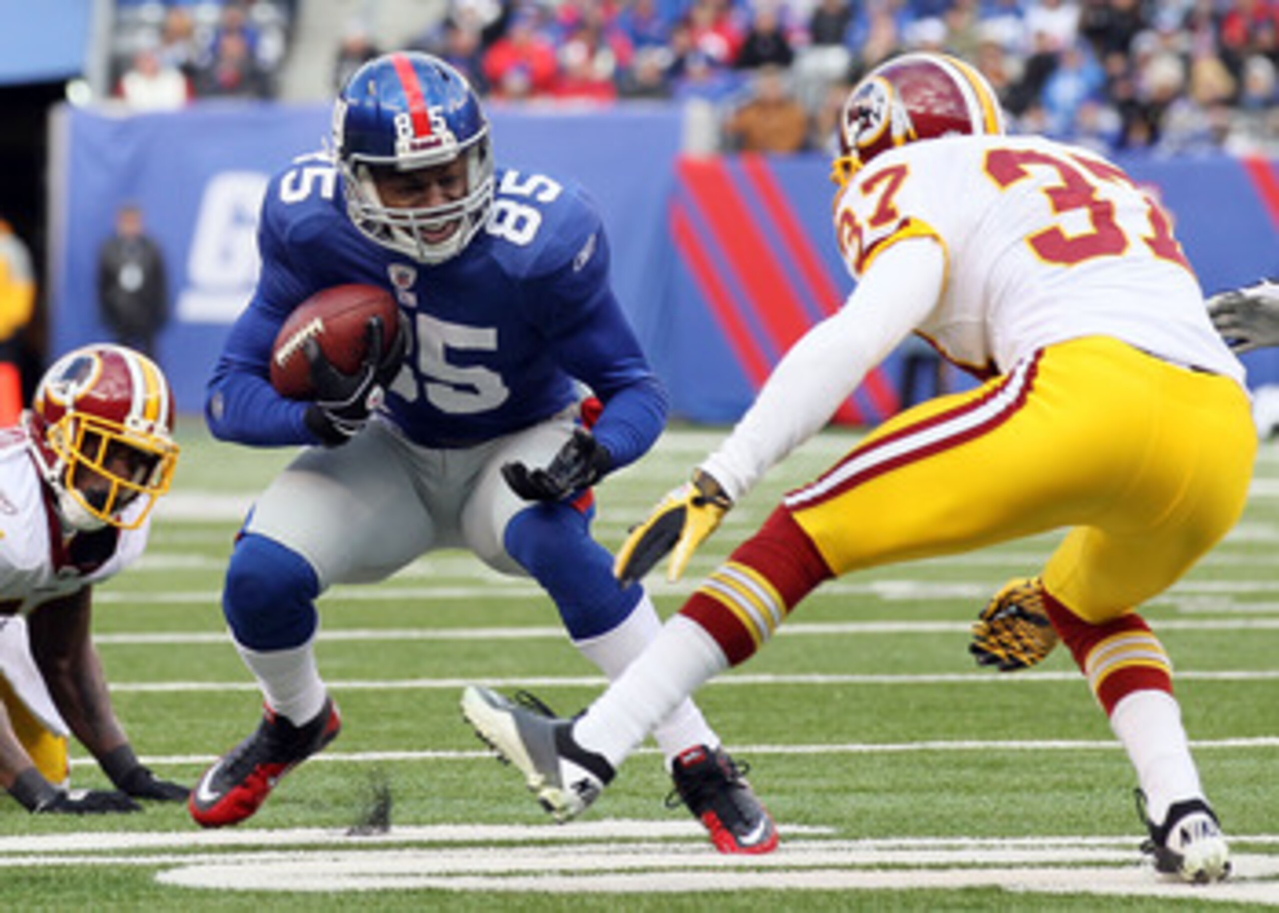 EAST RUTHERFORD, NJ - DECEMBER 05:  Derek Hagan #85 of the New York Giants runs the ball against Reed Doughty #37 of the Washington Redskins on December 5, 2010 at the New Meadowlands Stadium in East Rutherford, New Jersey.  (Photo by Jim McIsaac/Getty Im