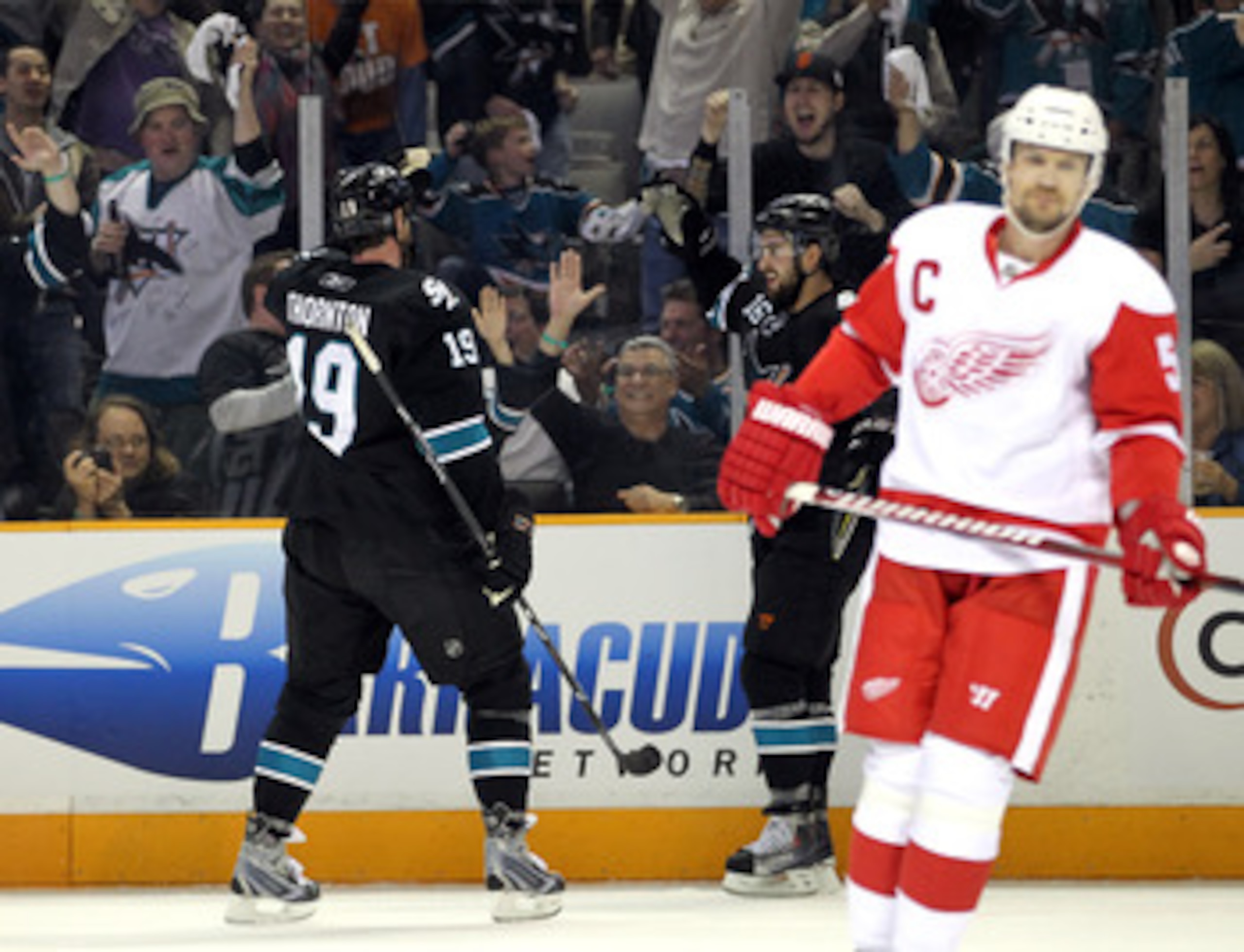 SAN JOSE, CA - MAY 08:  Joe Thornton #19 and Devin Setoguchi #16 of the San Jose Sharks celebrate behind Nicklas Lidstrom #5 of the Detroit Red Wings after Setoguchi scored a goal in Game Five of the Western Conference Semifinals during the 2011 NHL Stanl