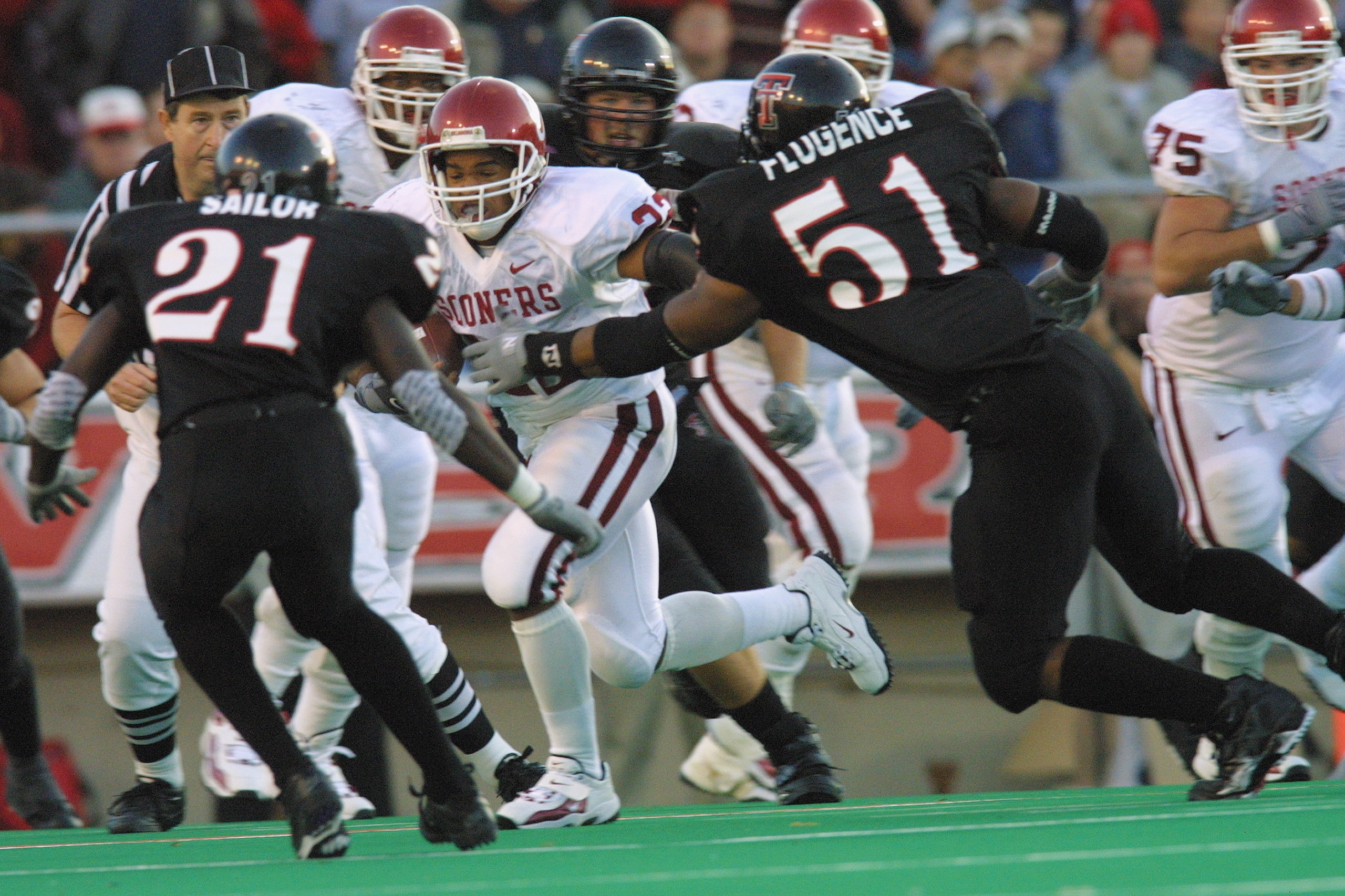 LUBBOCK, TX - NOVEMBER 17:  Running back Quentin Griffin #22 of  Oklahoma runs with the ball while being defended by Ricky Sailor #21 and Lawrence Flugence #51 of Texas Tech during the game on November 17, 2001 at Jones SBC Stadium in Lubbock, Texas.  The