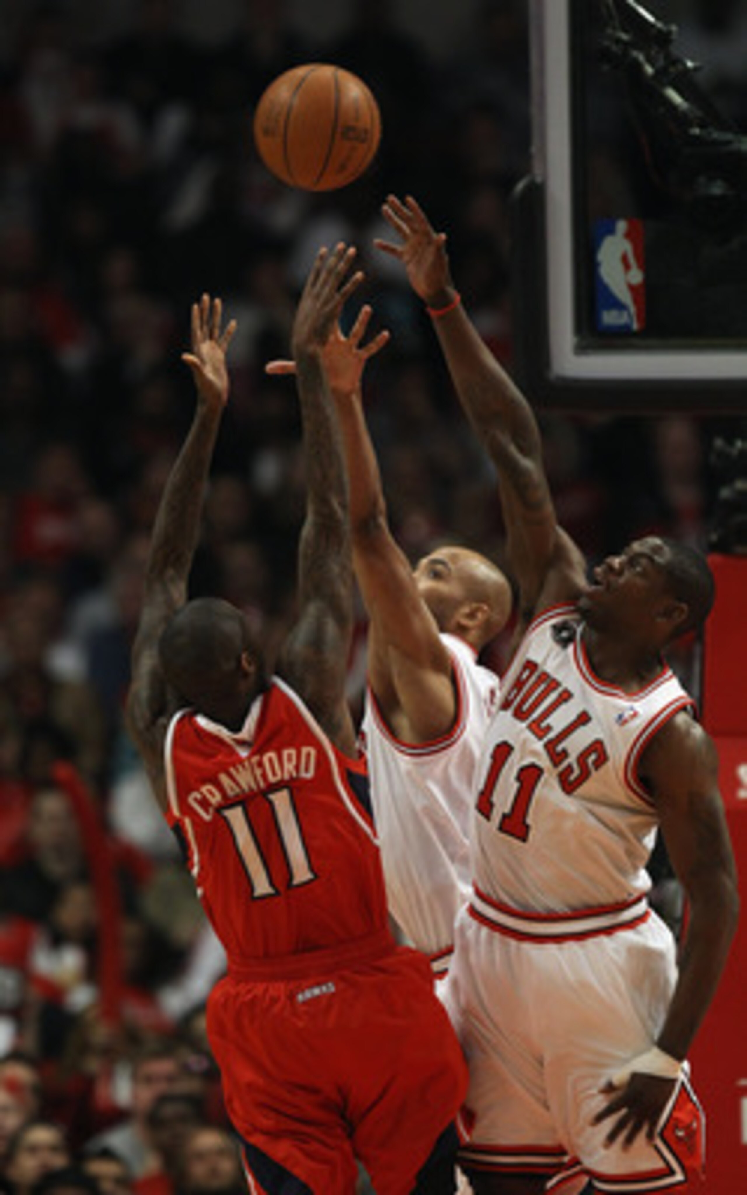 CHICAGO, IL - MAY 04: Jamal Crawford #11 of the Atlanta Hawks puts up a shot under pressure from Ronnie Brewer #11 and Taj Gibson #22 of the Chicago Bulls in Game Two of the Eastern Conference Semifinals in the 2011 NBA Playoffs at the United Center on Ma