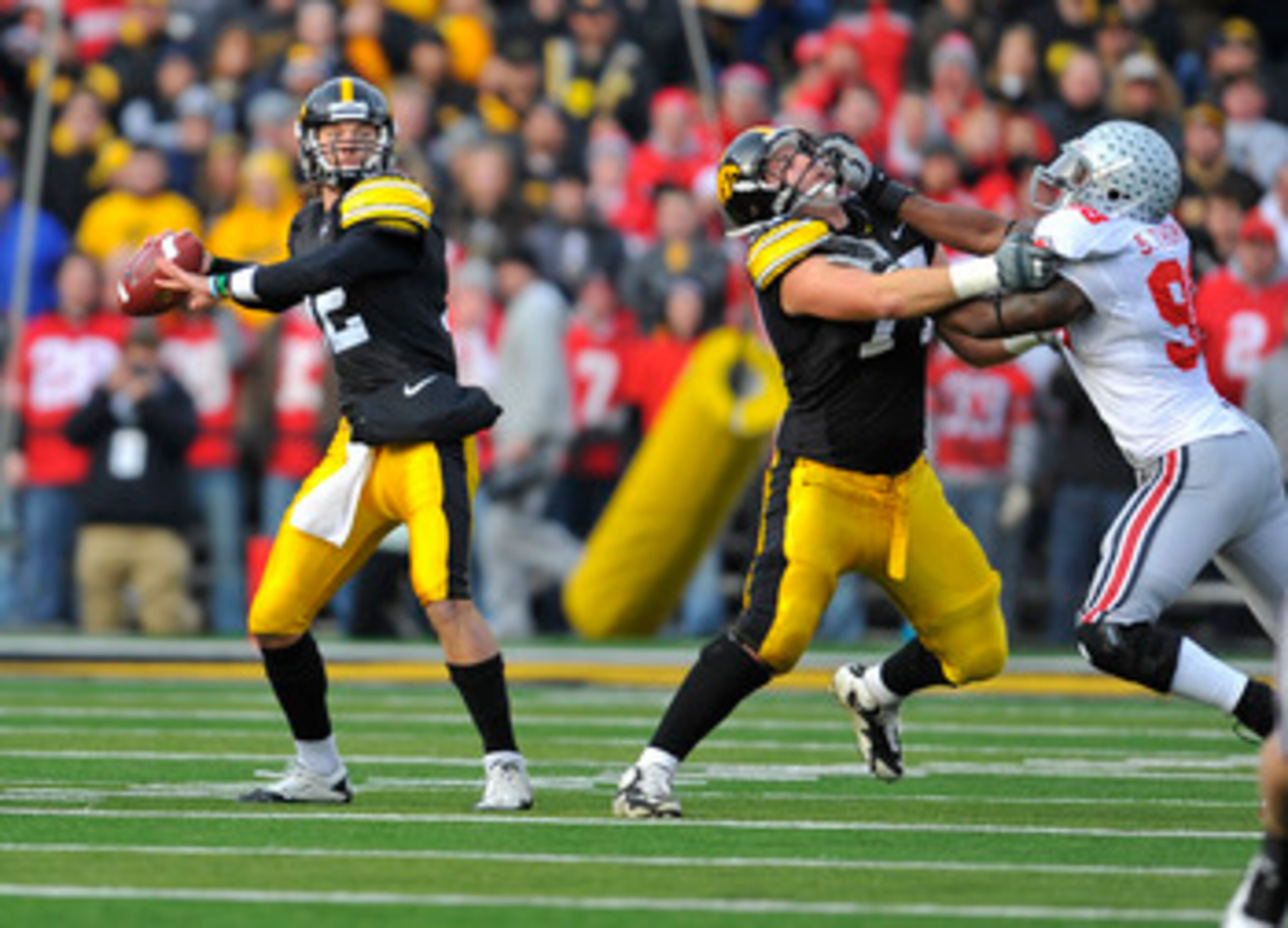 IOWA CITY, IA - NOVEMBER 20:  Quarterback Ricky Stanzi #12 of the University of Iowa Hawkeyes throws under pressure from defensive lineman Solomon Thomas #98 of the Ohio State Buckeyes as offensive lineman Riley Reiff #77 defends during the first half of 