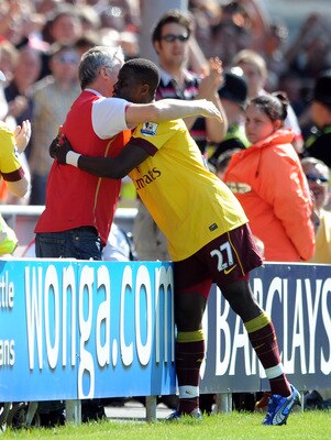 BLACKPOOL, ENGLAND - APRIL 10: Emmanuel Eboue of Arsenal celebrates scoring his side's second goal with a supporter during the Barclays Premier League match between Blackpool and Arsenal at Bloomfield Road on April 10, 2011 in Blackpool, England.  (Photo 