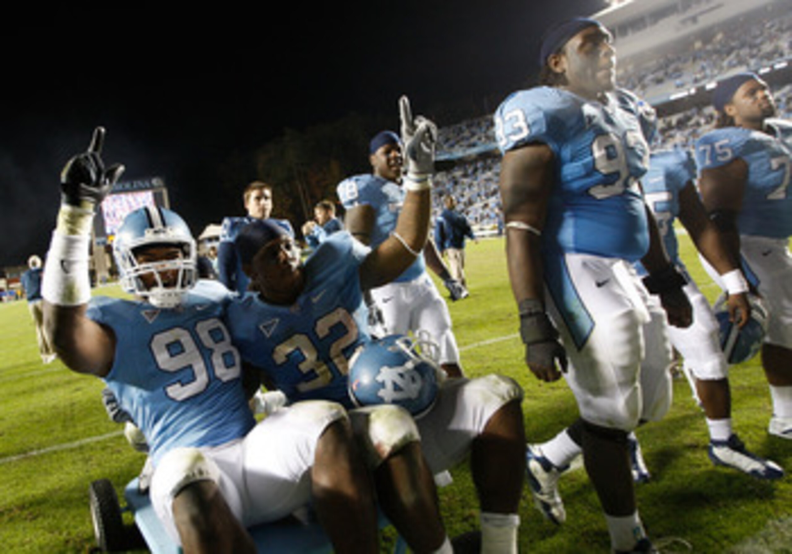 CHAPEL HILL, NC - NOVEMBER 07: Teammates Donte Paige-Moss #98 and Ryan Houston #32 of the North Carolina Tar Heels celebrate after defeating the Duke Blue Devils 19-6 during their game at Kenan Stadium on November 7, 2009 in Chapel Hill, North Carolina. CHAPEL HILL, NC - NOVEMBER 07: Teammates Donte Paige-Moss #98 and Ryan Houston #32 of the North Carolina Tar Heels celebrate after defeating the Duke Blue Devils 19-6 during their game at Kenan Stadium on November 7, 2009 in Chapel Hill, North Carolina.