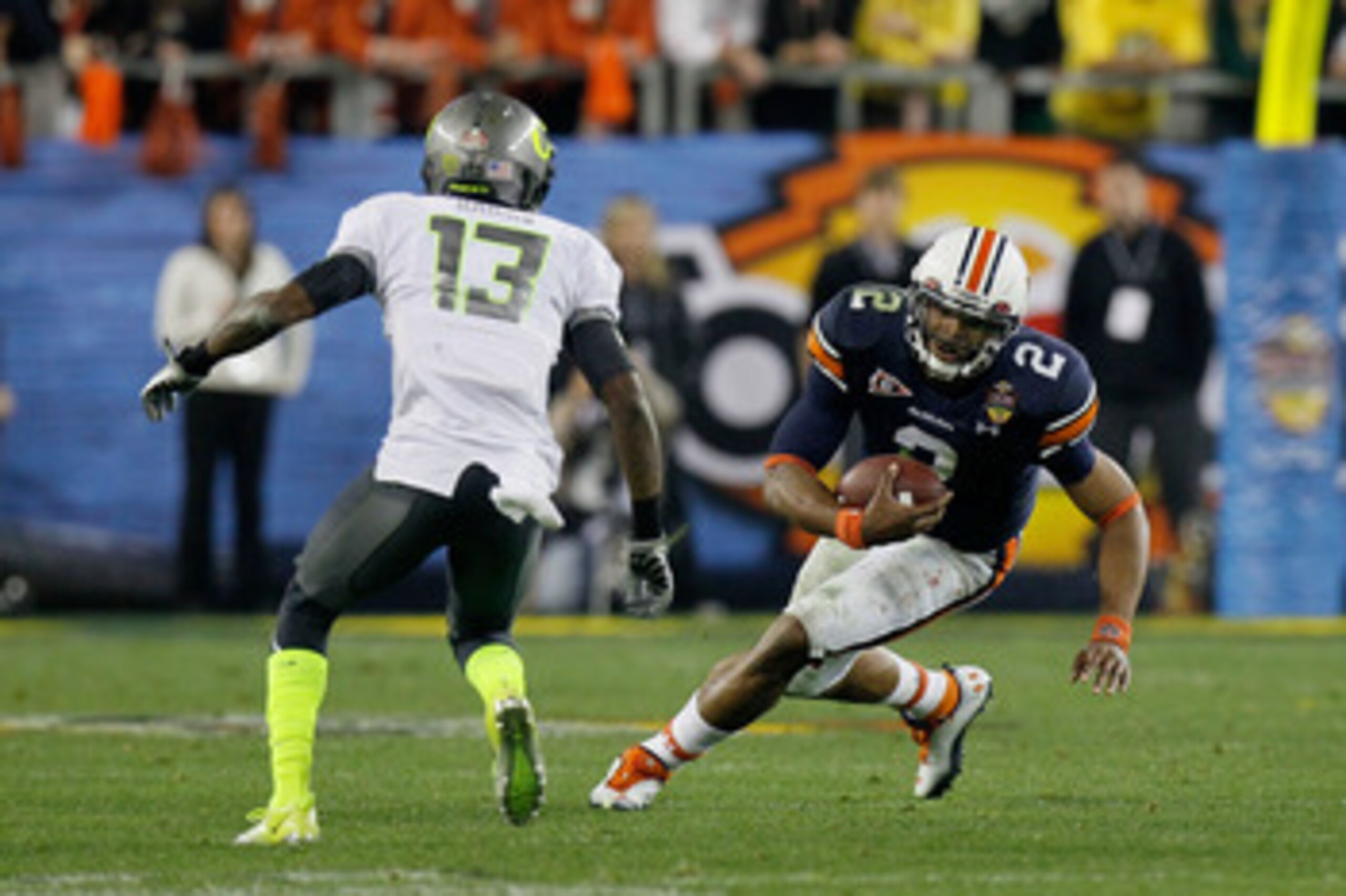GLENDALE, AZ - JANUARY 10: Cameron Newton #2 of the Auburn Tigers runs down field against Cliff Harris #13 of the Oregon Ducks during the Tostitos BCS National Championship Game at University of Phoenix Stadium on January 10, 2011 in Glendale, Arizona. GLENDALE, AZ - JANUARY 10: Cameron Newton #2 of the Auburn Tigers runs down field against Cliff Harris #13 of the Oregon Ducks during the Tostitos BCS National Championship Game at University of Phoenix Stadium on January 10, 2011 in Glendale, Arizona.