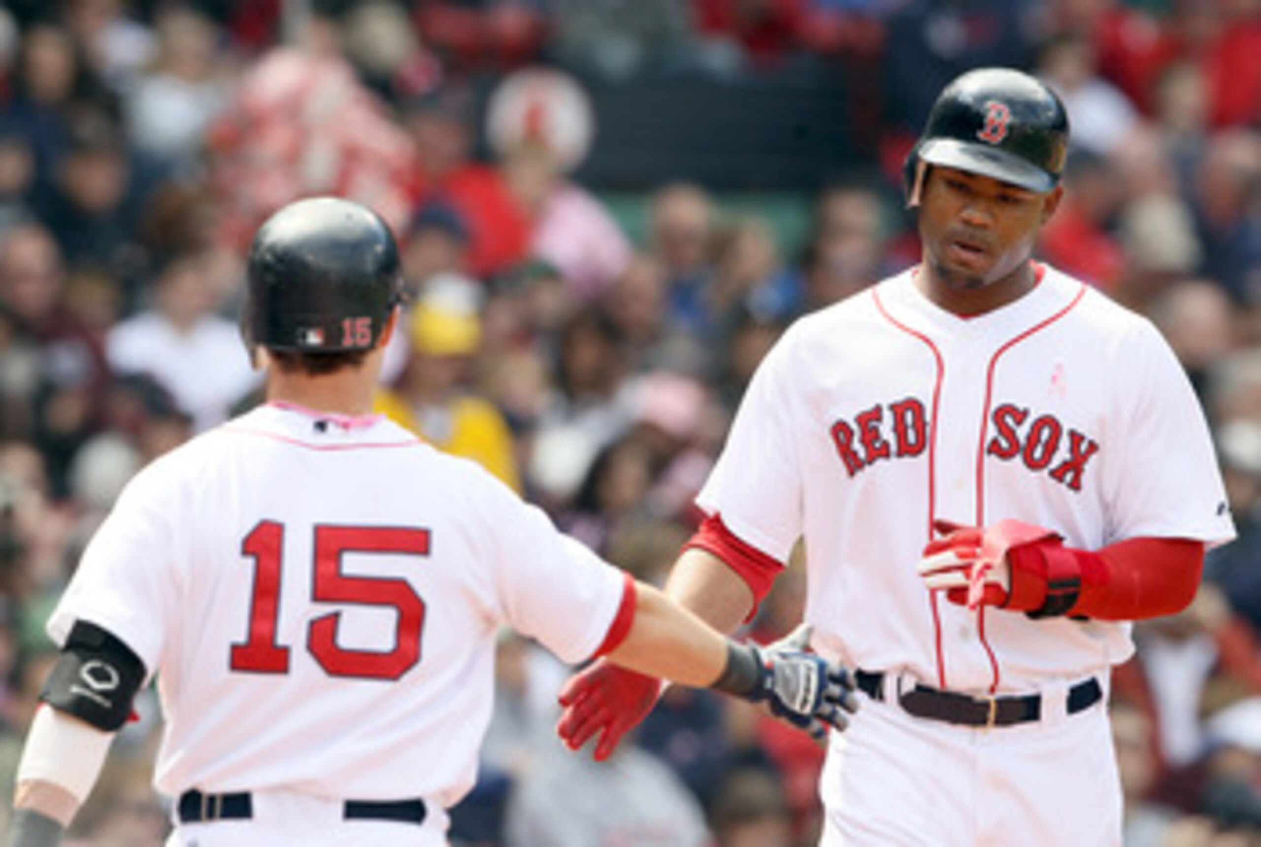 BOSTON, MA - MAY 08:  Carl Crawford #13 of the Boston Red Sox is congratulated by Dustin Pedroia #15 after Crawford scored in the third inning against the Minnesota Twins on May 8, 2011 at Fenway Park in Boston, Massachusetts.  (Photo by Elsa/Getty Images