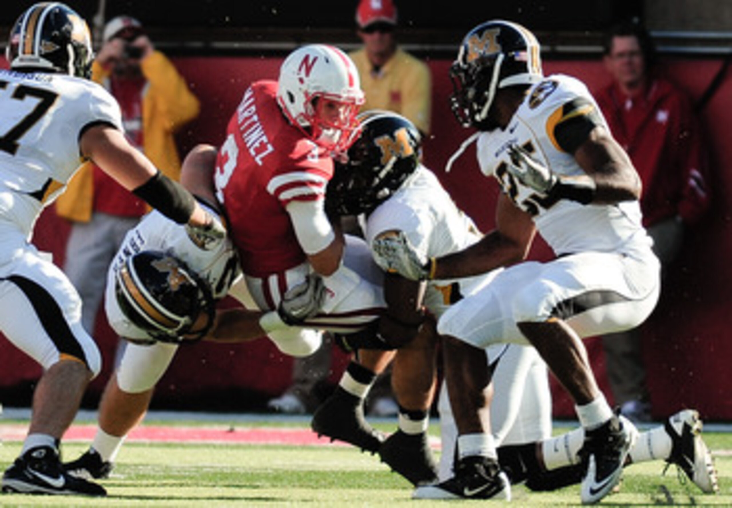 LINCOLN, NE - OCTOBER 30: Quarterback Taylor Martinez #3 of the Nebraska Cornhuskers tries to slip between Missouri Tiger defenders during first half action of their game at Memorial Stadium on October 30, 2010 in Lincoln, Nebraska. Nebraska Defeated Miss