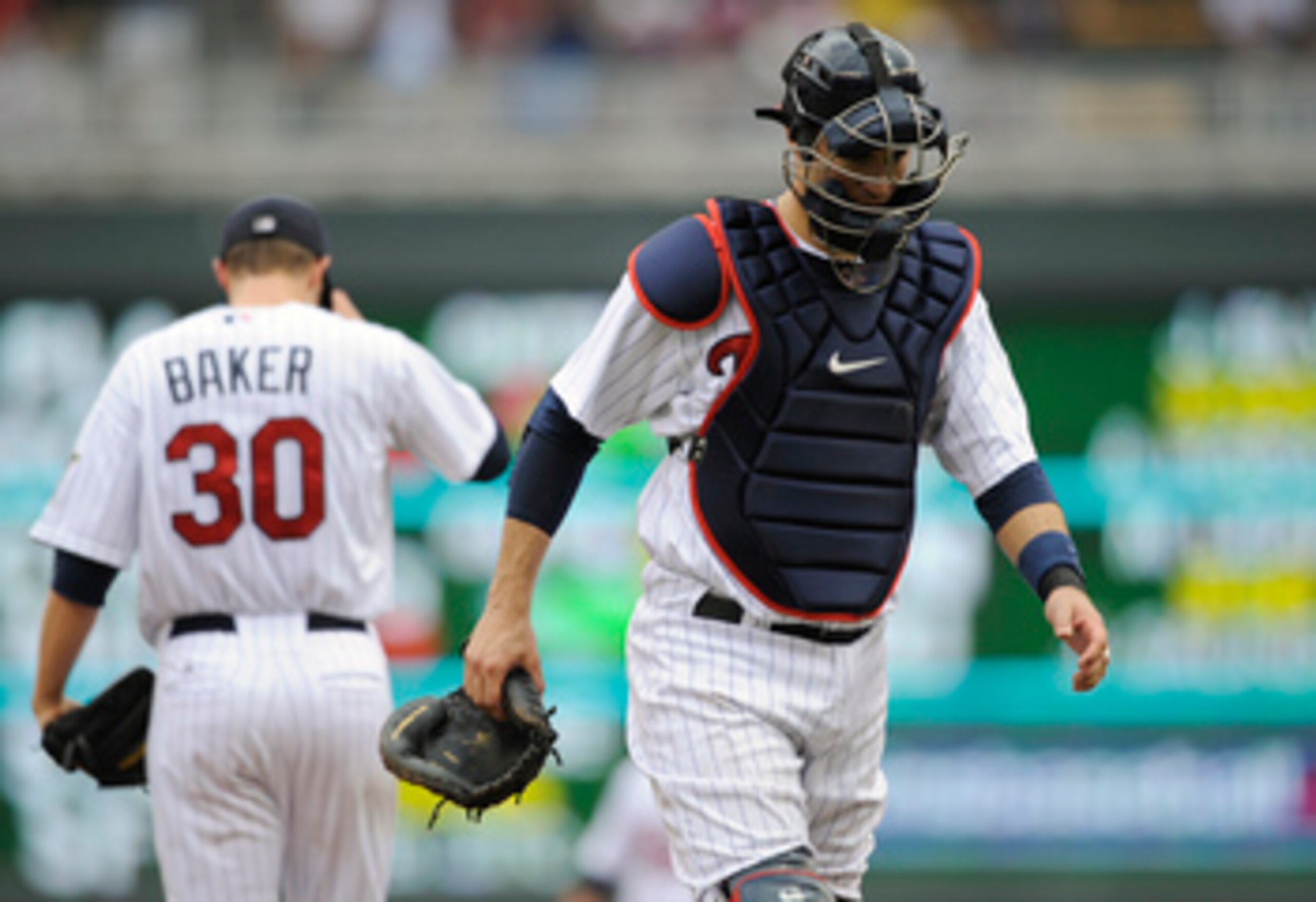 MINNEAPOLIS, MN - APRIL 10: Catcher Joe Mauer #7 of the Minnesota Twins return to home plate after speaking with Scott Baker #30 on the mound during the fourth inning of their game against the Oakland Athletics on April 10, 2011 at Target Field in Minneap