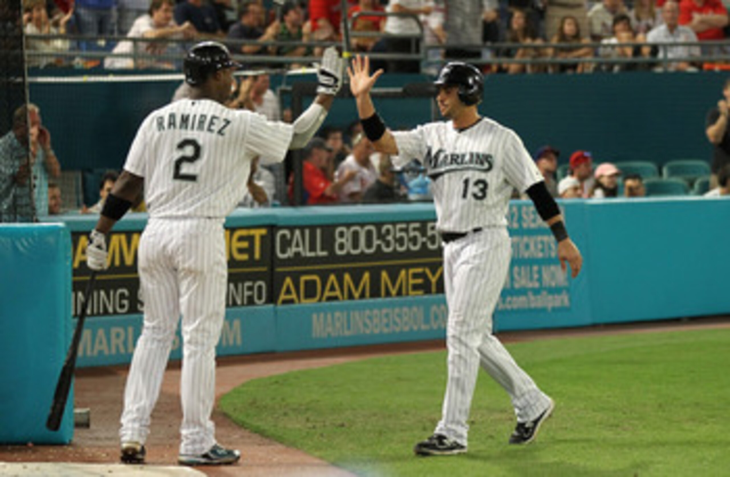 MIAMI GARDENS, FL - MAY 10:  Omar Infante #13 of the Florida Marlins is congratulated By Hanley Ramirez #2 after scoring the go ahead run during a game against the Philadelphia Phillies at Sun Life Stadium on May 10, 2011 in Miami Gardens, Florida.  (Phot