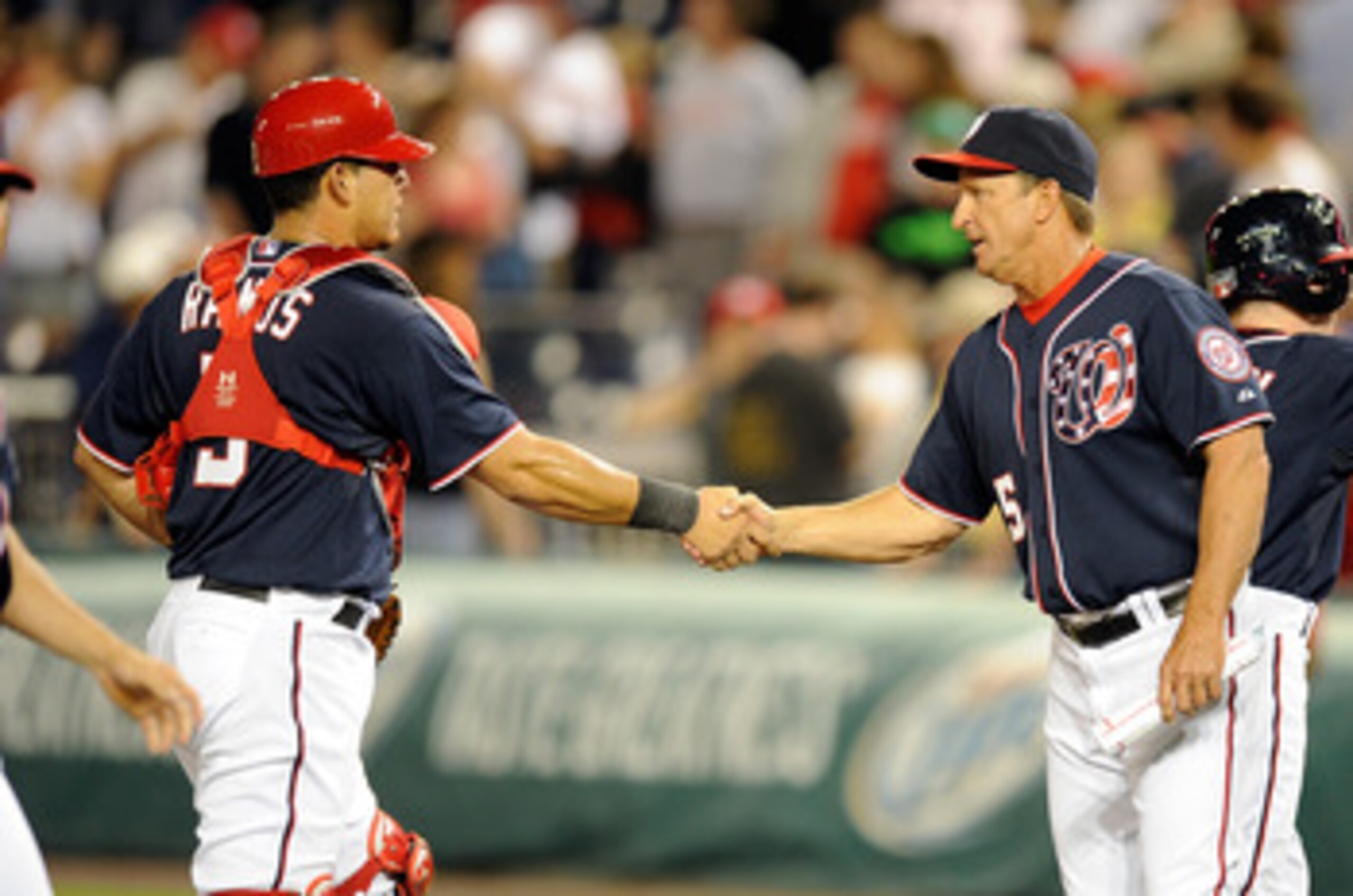WASHINGTON, DC - MAY 02:  Wilson Ramos #3 of the Washington Nationals celebrates with manager Jim Riggleman #5 after a 2-0 victory against the San Francisco Giants at Nationals Park on May 2, 2011 in Washington, DC.  (Photo by Greg Fiume/Getty Images)