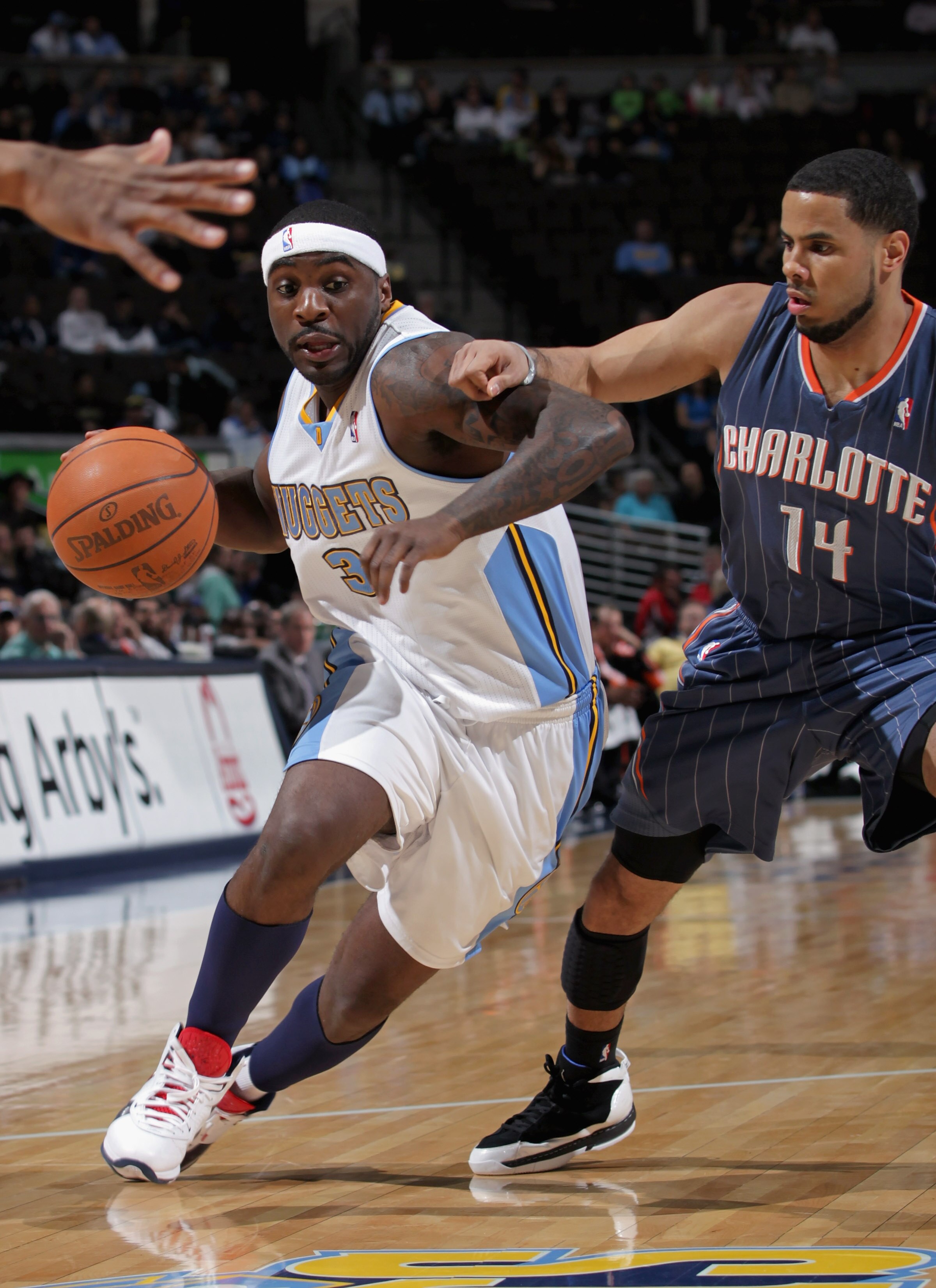 DENVER, CO - MARCH 02:  Ty Lawson #3 of the Denver Nuggets drives to the basket against D.J. Augustin #14 of the Charlotte Bobcats at the Pepsi Center on March 2, 2011 in Denver, Colorado. The Nuggets defeated the Bobcats 120-80. NOTE TO USER: User expres