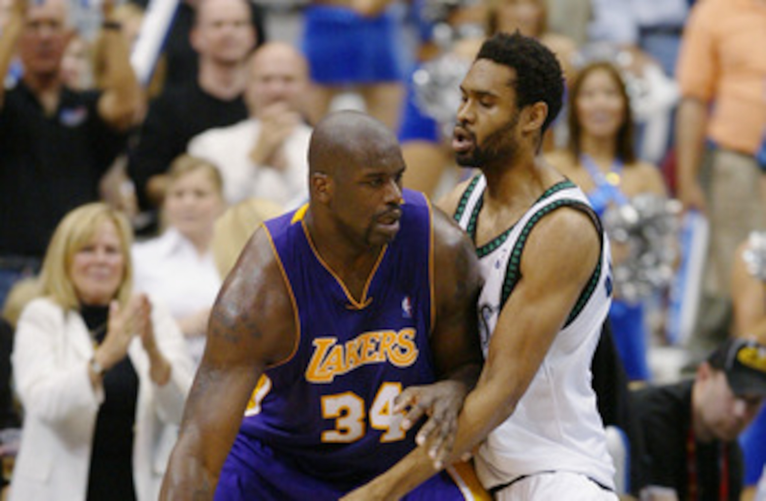 MINNEAPOLIS - MAY 29:  Shaquille O'Neal #34 of the Los Angeles Lakers dribbles the ball against Michael Olowokandi #34 of the Minnesota Timberwolves in Game five of the Western Conference Finals during the 2004 NBA Playoffs on May 29, 2004 atTarget Center